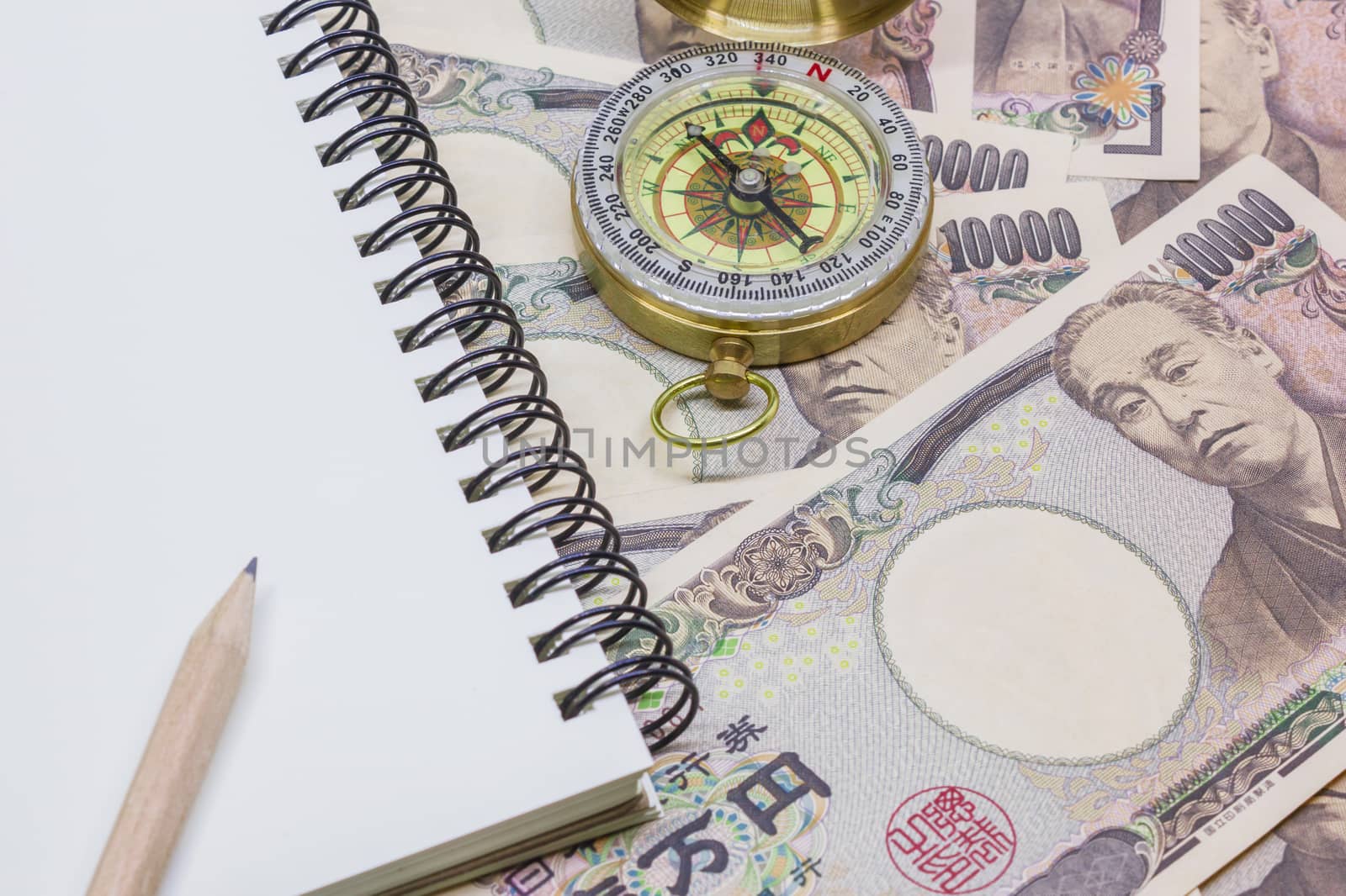 pencil on note book, compass with banknotes ten thousand yen for by rakoptonLPN