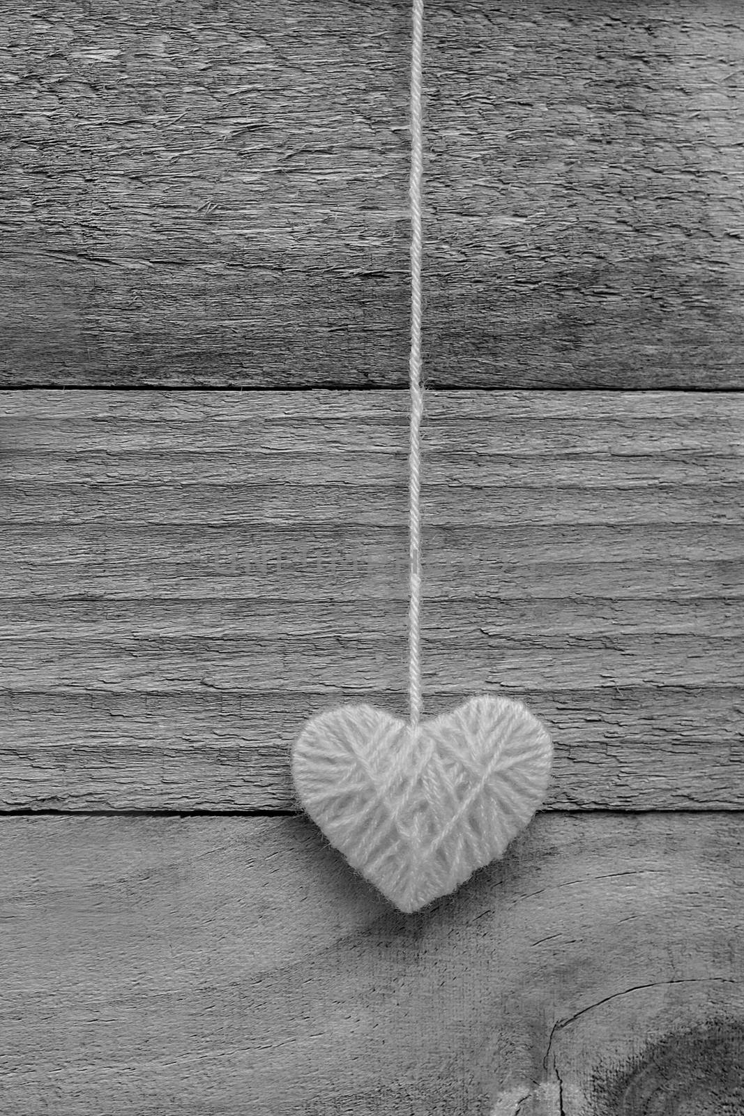 heart shape made from knitting wool on old shabby wooden backgro by rakoptonLPN