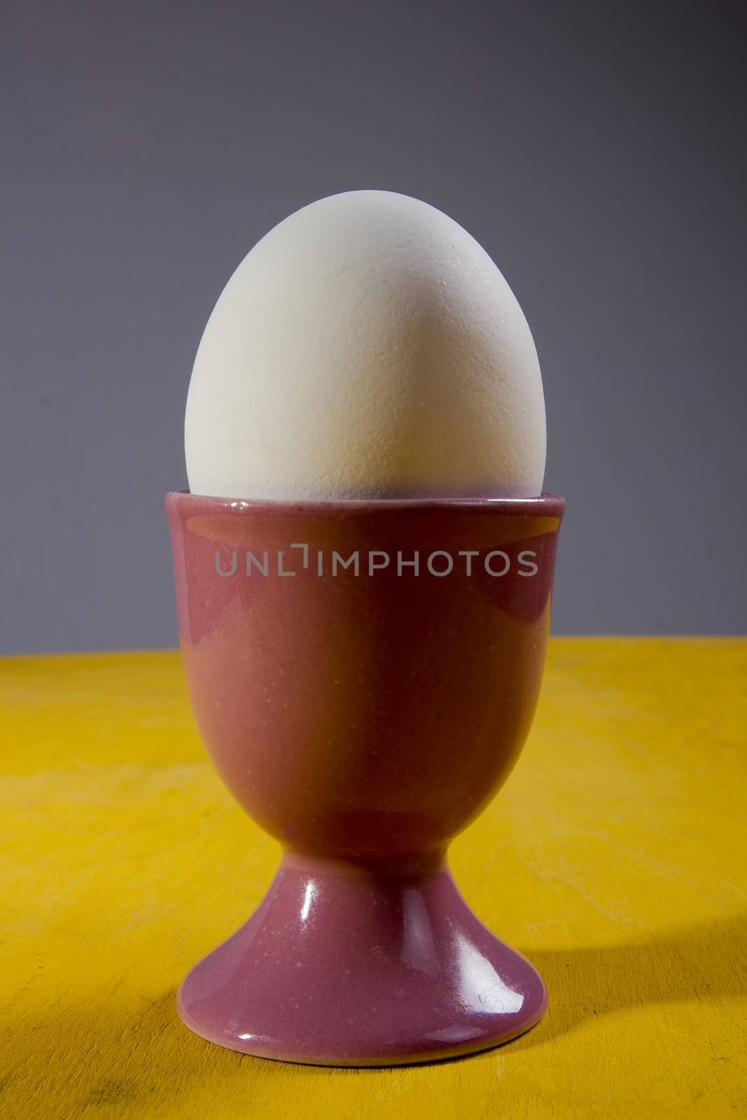 Cooked egg in a holder on a wooden table