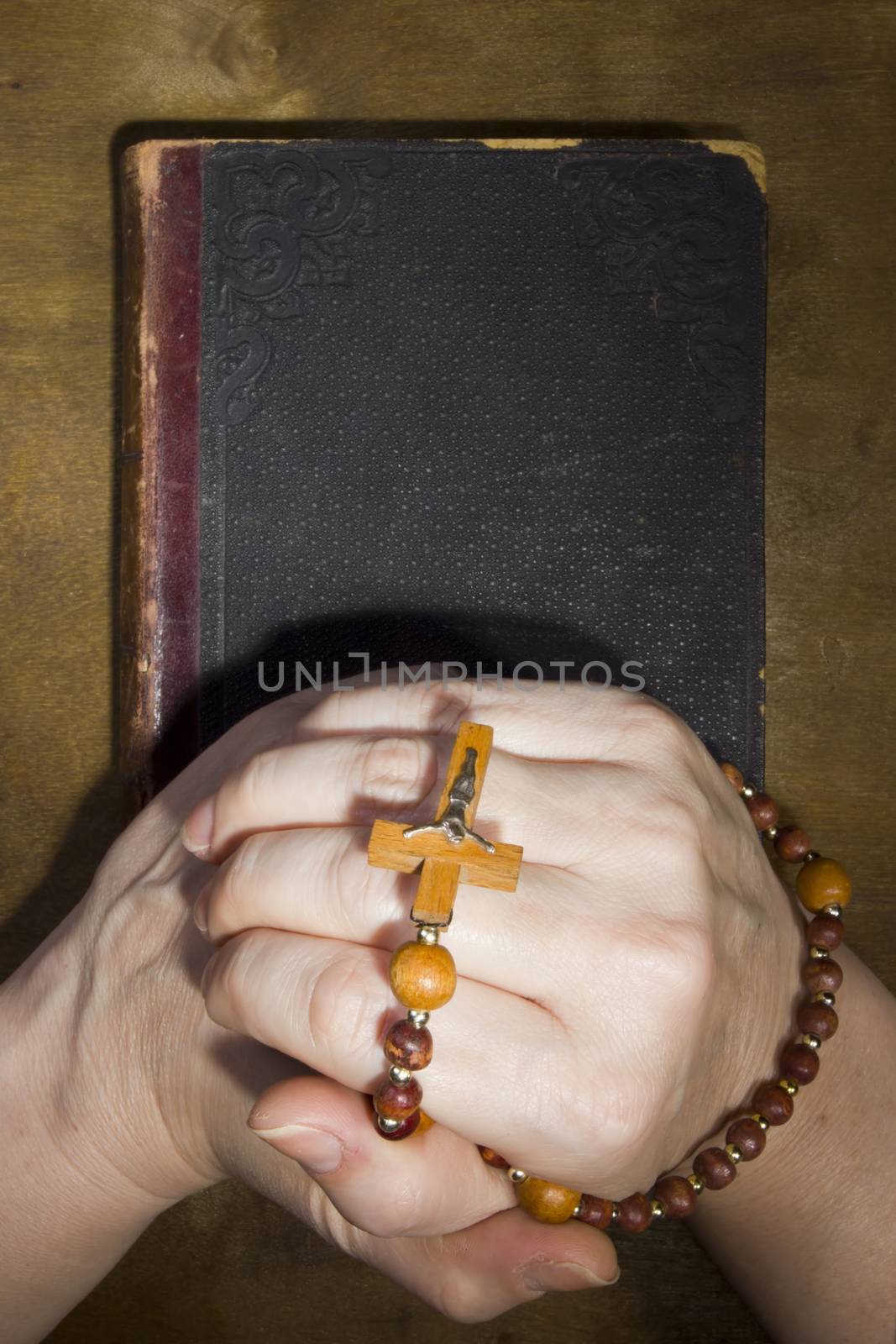 Hands with rosary and an old book by VIPDesignUSA