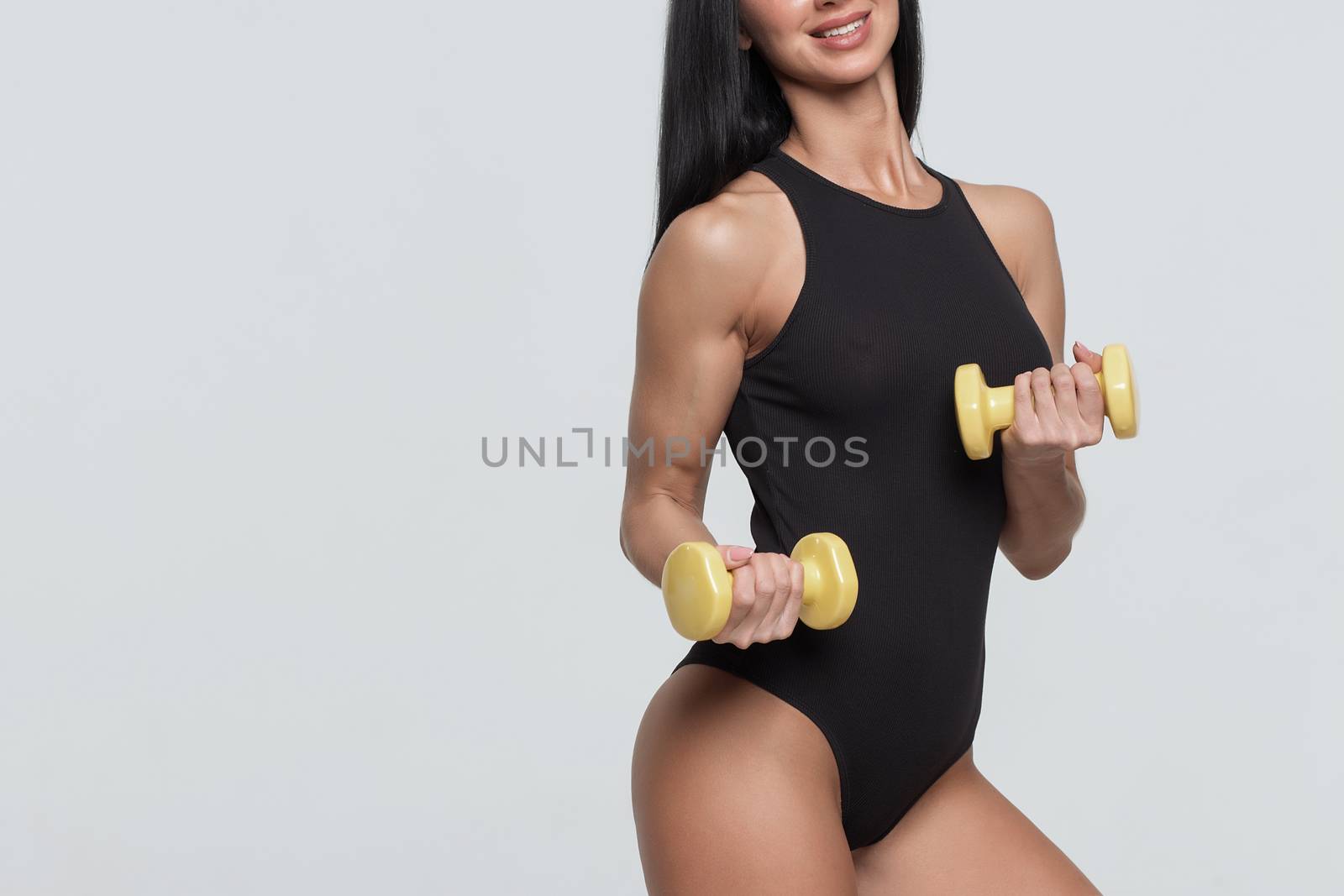 Fitness woman exercising crossfit holding dumbbell strength training biceps.