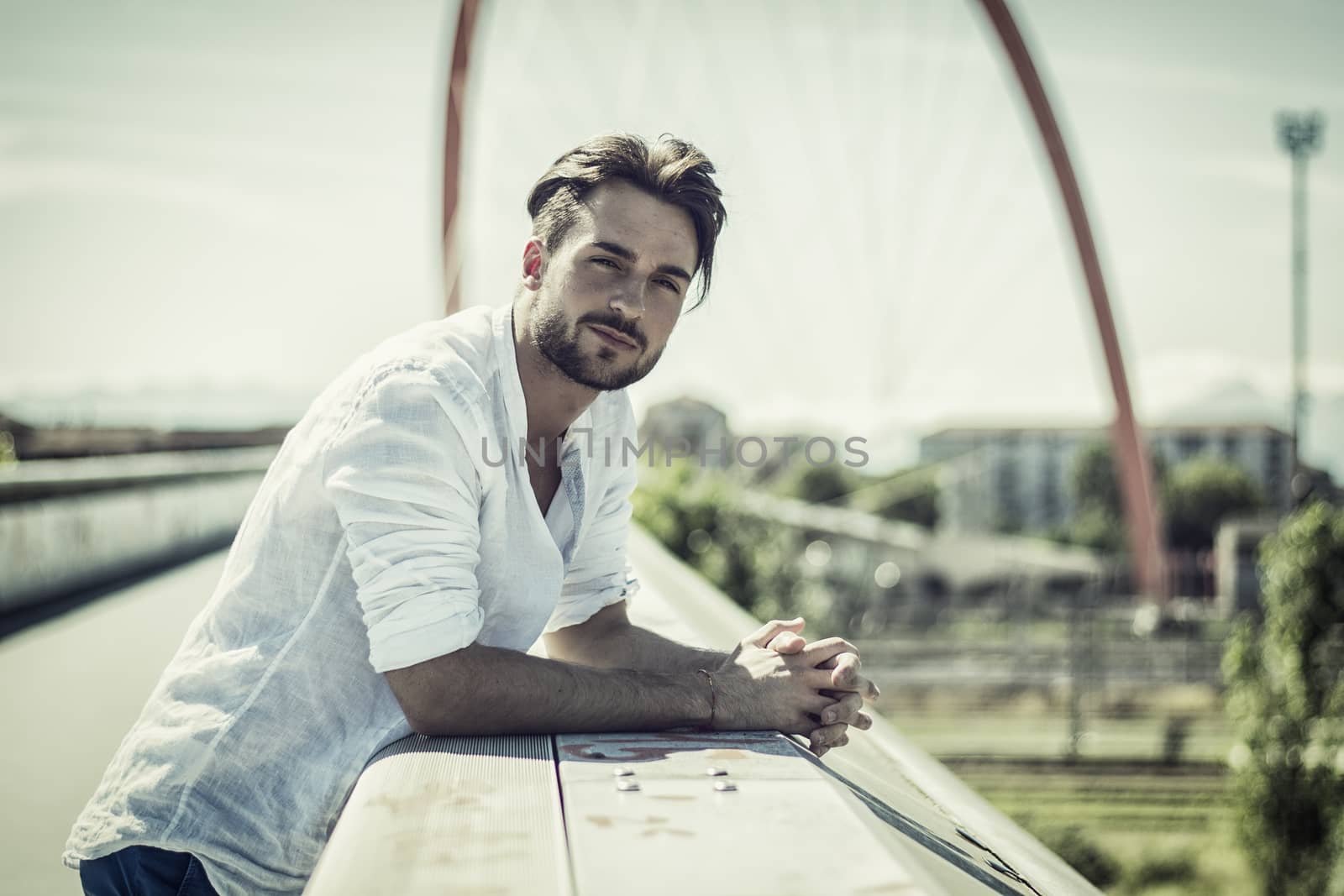 One handsome young man in urban setting in European city, standing