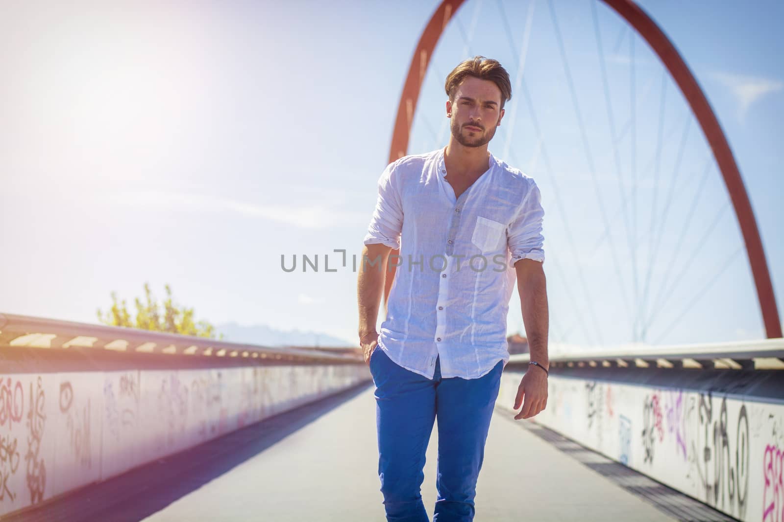 One handsome young man in urban setting in European city, standing