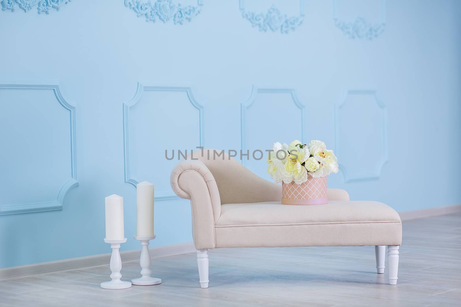 Interior mock up photo. Blue wall with leather material divan sofa and pot with plant flowers and ladder. Background photo with copy space for text