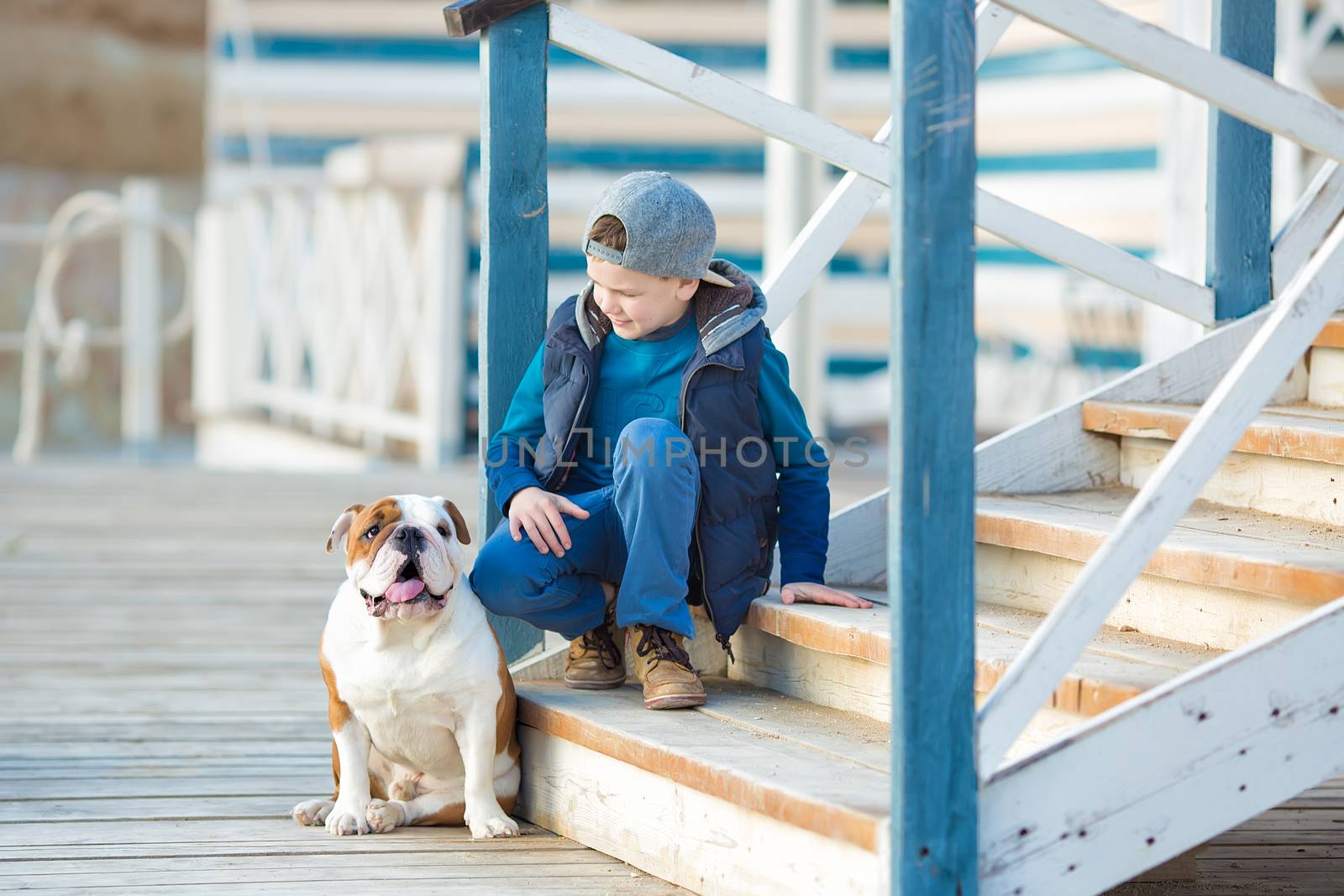 Nice looking handsome boy on beach with english bulldog