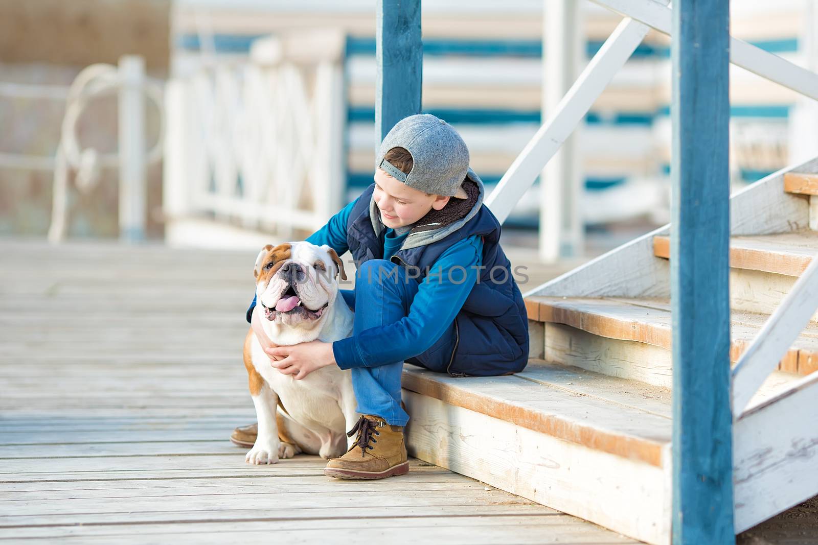 Nice looking handsome boy on beach with english bulldog