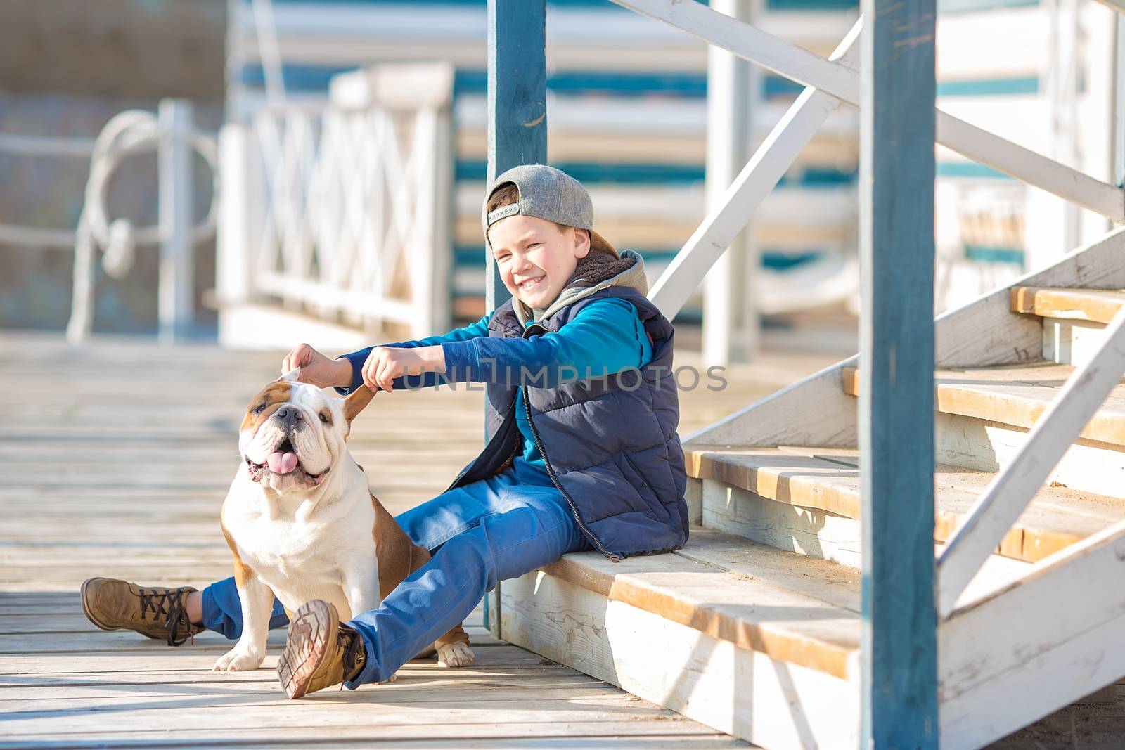 Nice looking handsome boy on beach with english bulldog