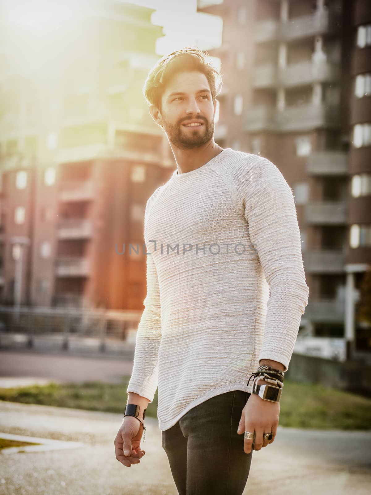 One handsome young man in urban setting in European city, standing