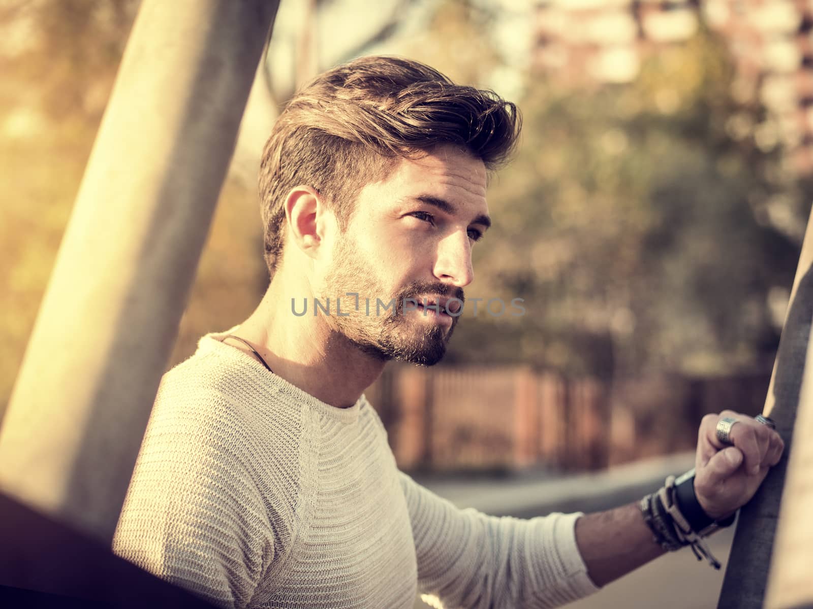 One handsome young man in urban setting in European city, standing