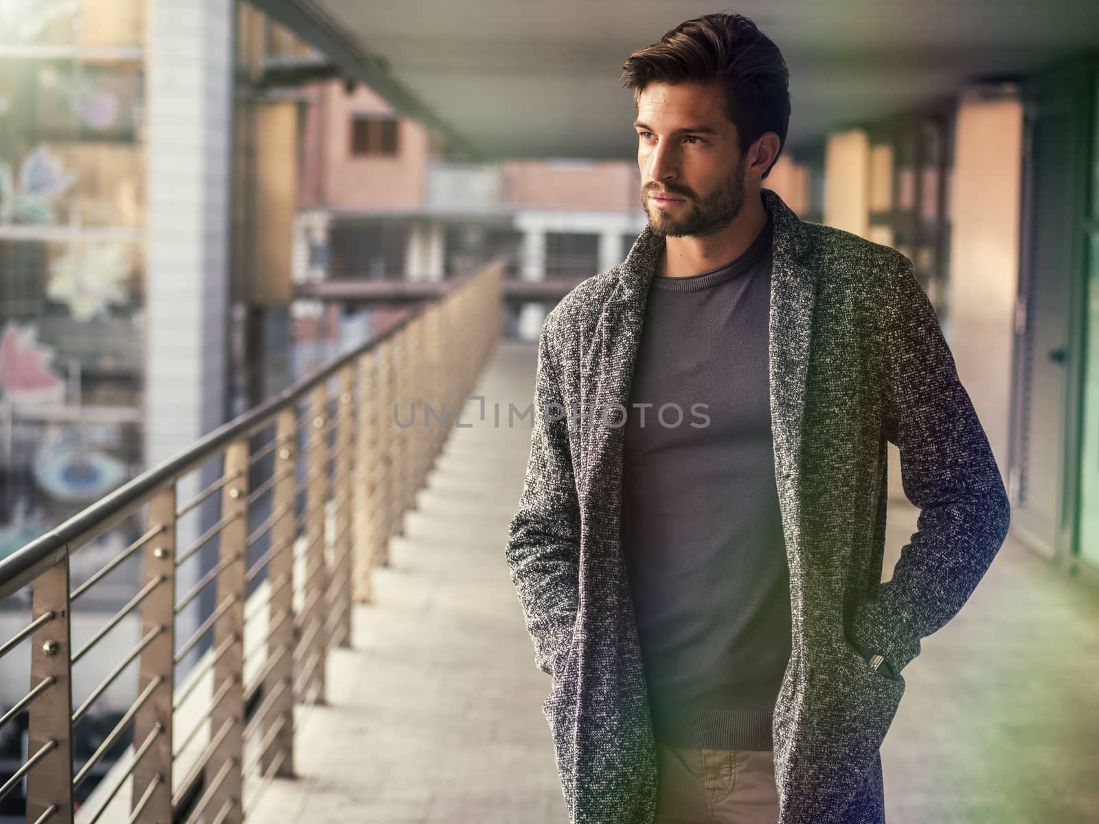 One handsome young man in urban setting in European city, standing