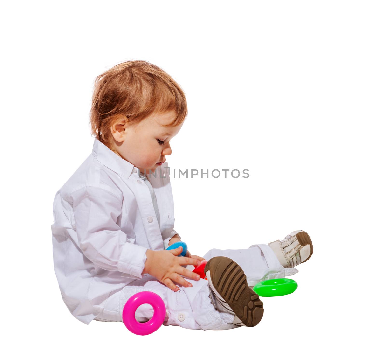 Baby boy playing with colorful pyramid toy isolated on white