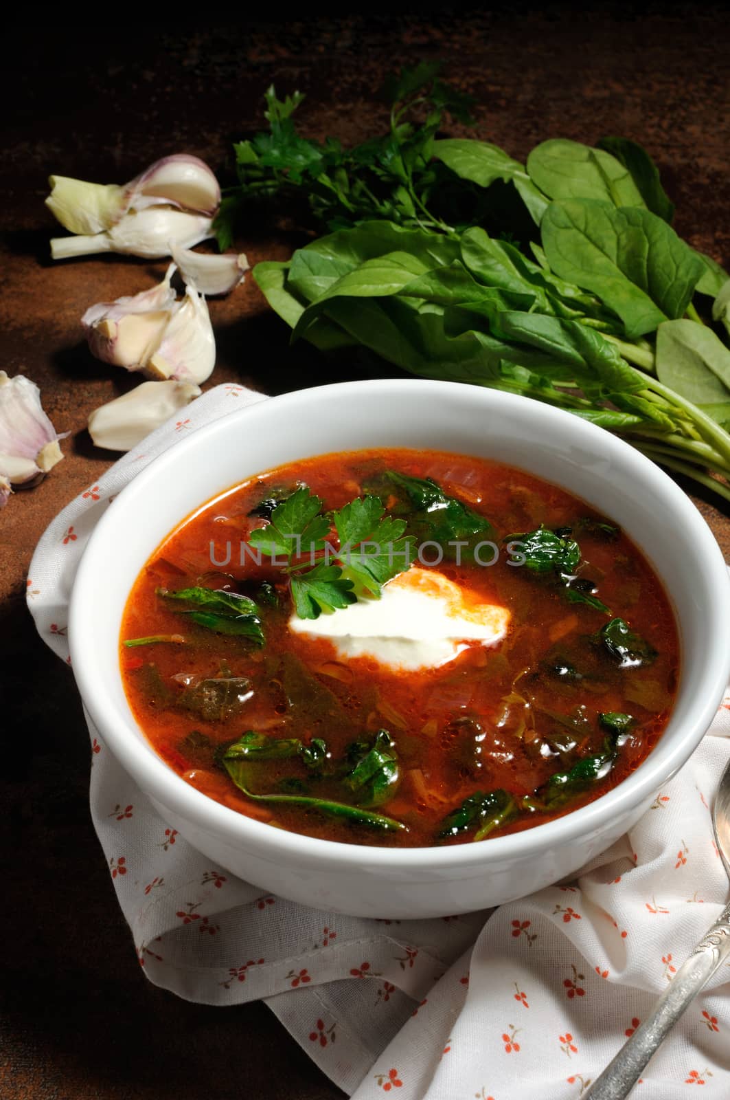 Vegetable bowl, tomato soup with spinach and sour cream. Vertical shot.