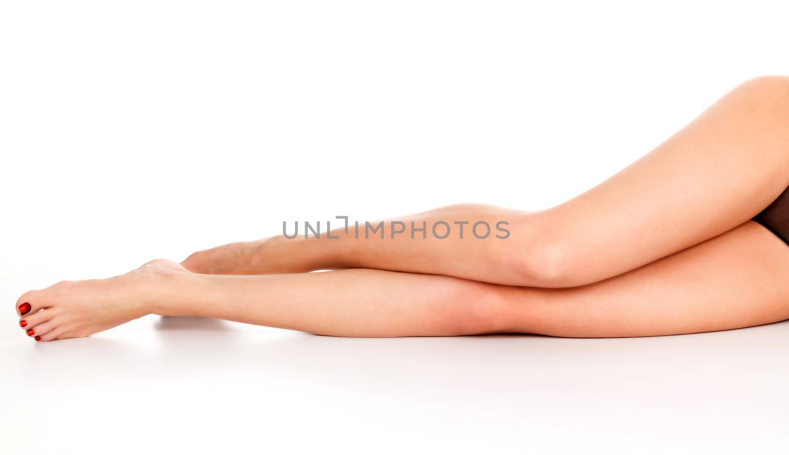 Closeup shot of long beautiful female legs. Woman with slim legs by Nobilior