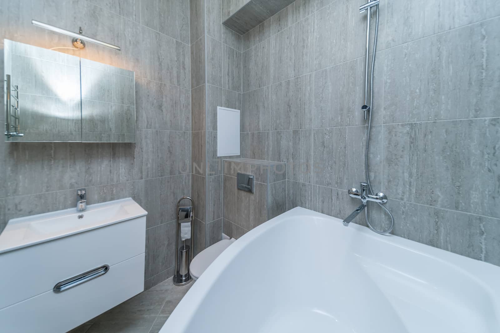 Small grey tile bathroom with bath tube and sink