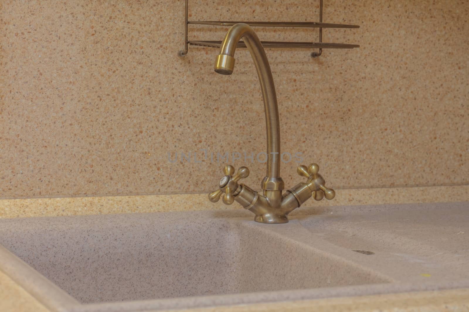 Close up of modern faucet and ceramic sink in kitchen