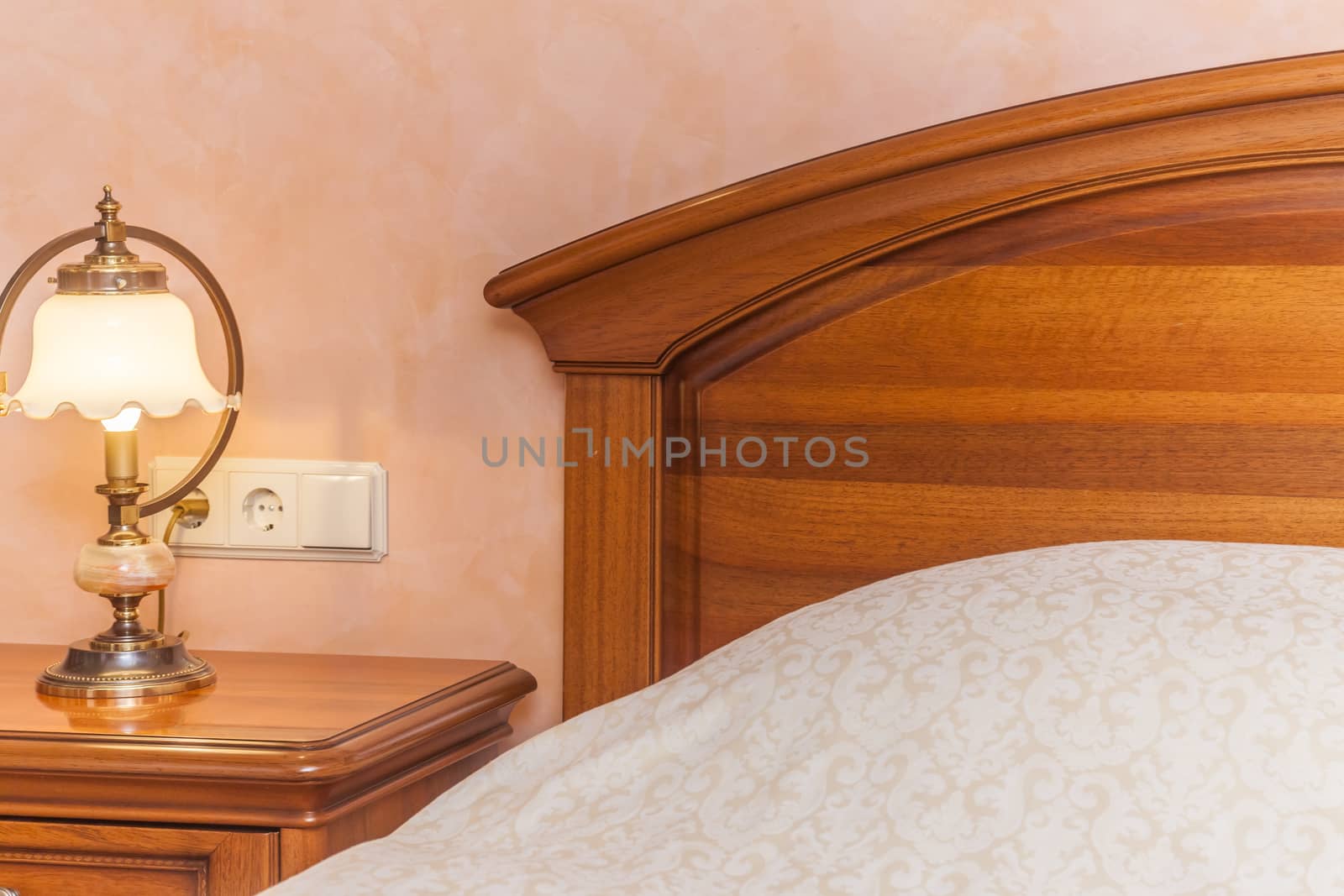 Warm cozy lamp near bed on nightstand