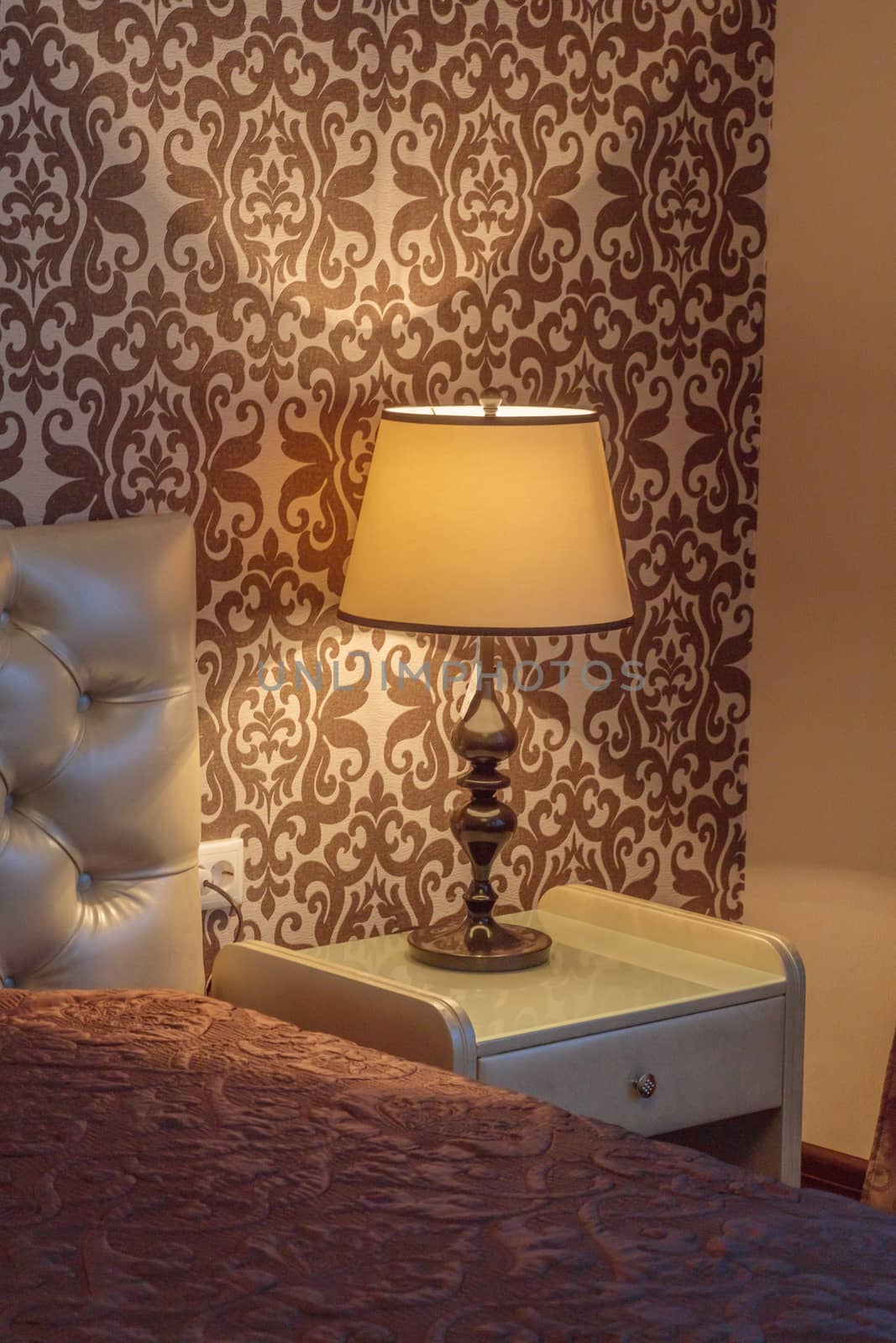 Warm cozy lamp near bed on nightstand