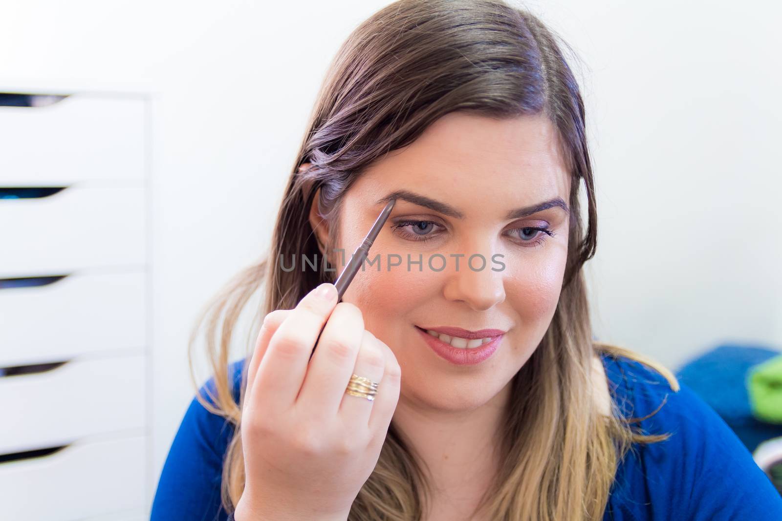 Woman applying makeup in her bedroom by wavemovies