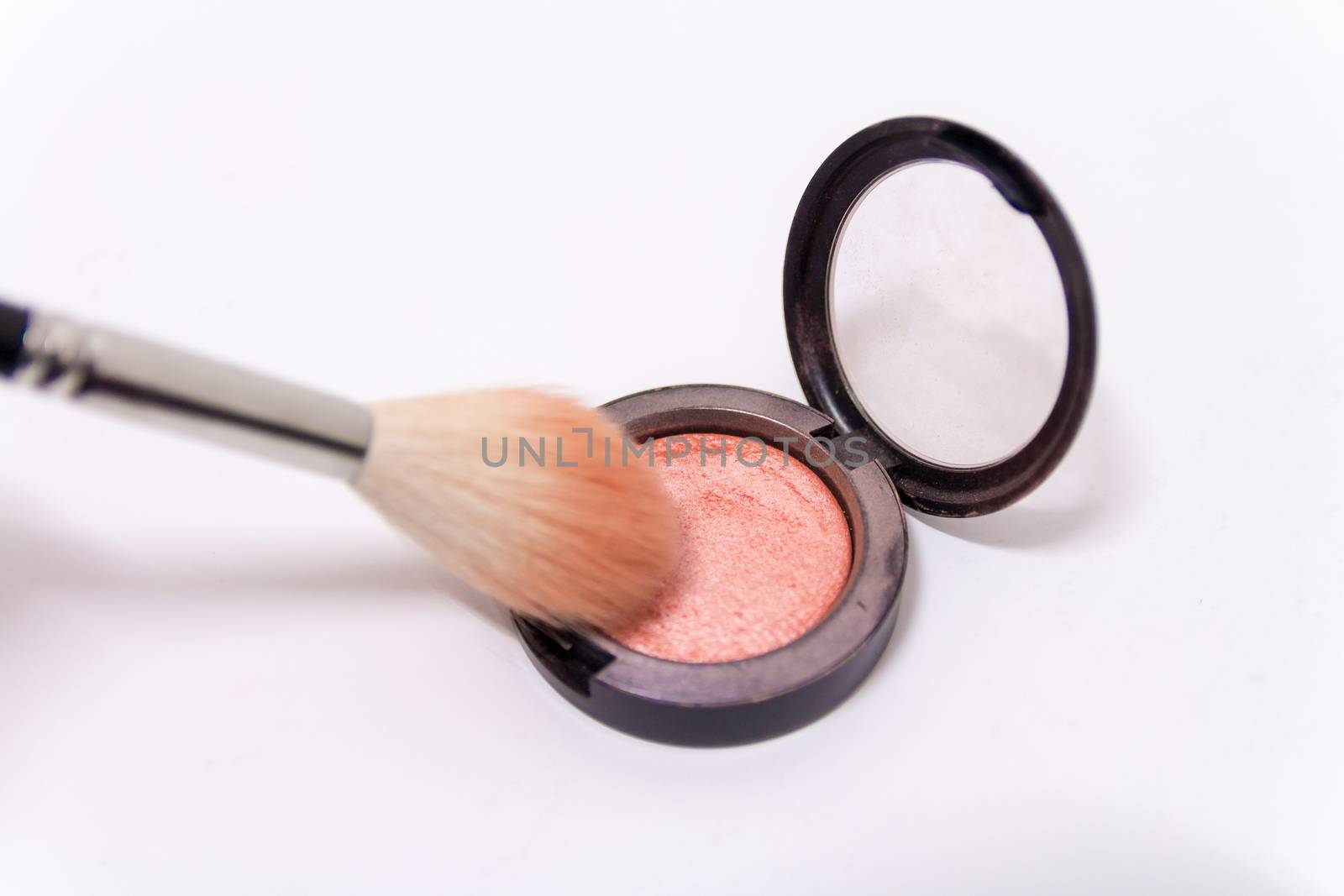 Close up of makeup brush and blush box isolated on white background.
