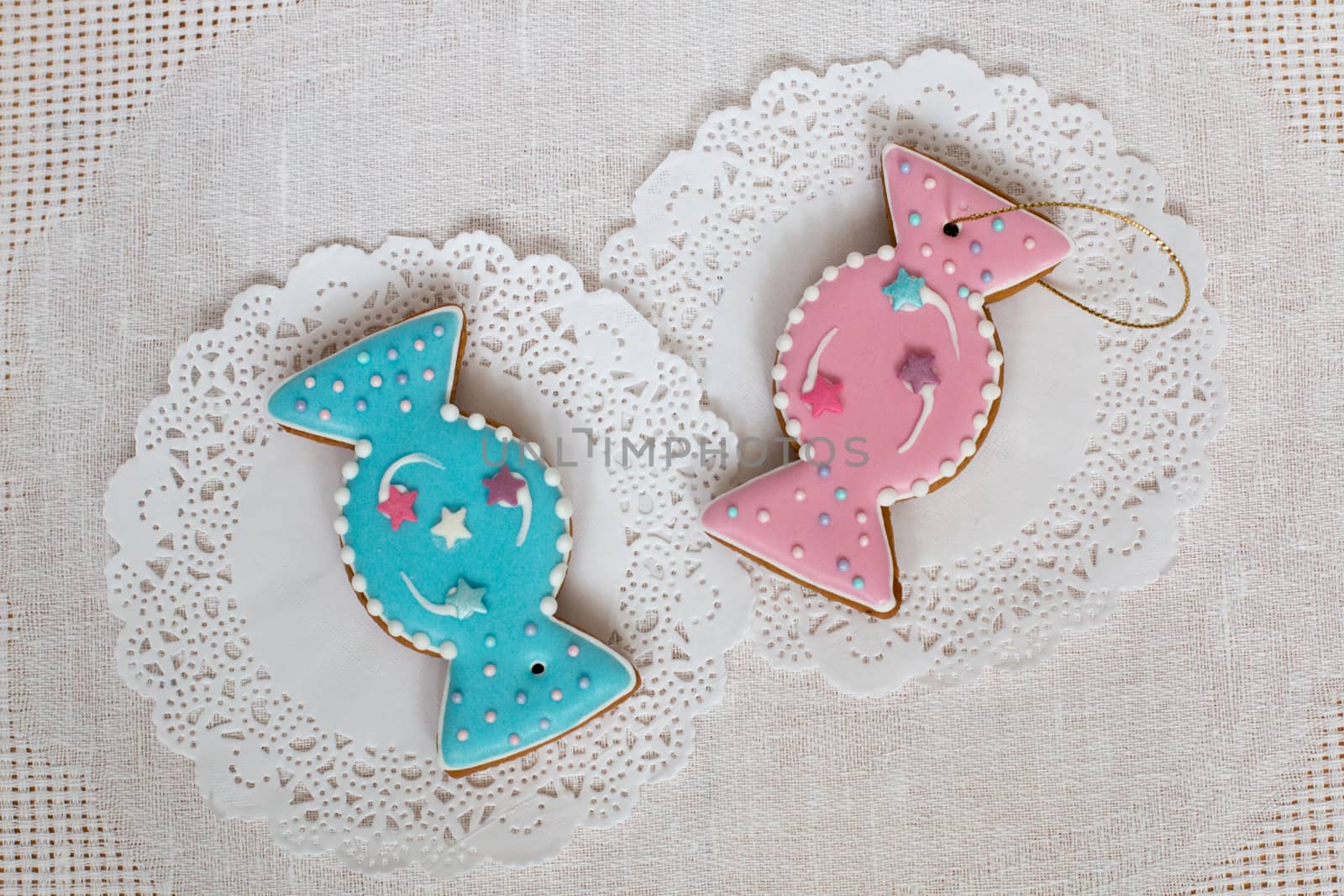 Two gingerbread cookies in the shape of candy on a white napkin background. Top view, flat lay, copy space. Curly Christmas gingerbread home cooking