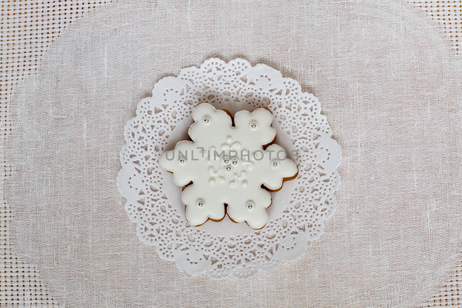 Christmas gingerbread snowflake on a background of napkin. Christmas toy gingerbread cookie, decorated with Icing. New year concept