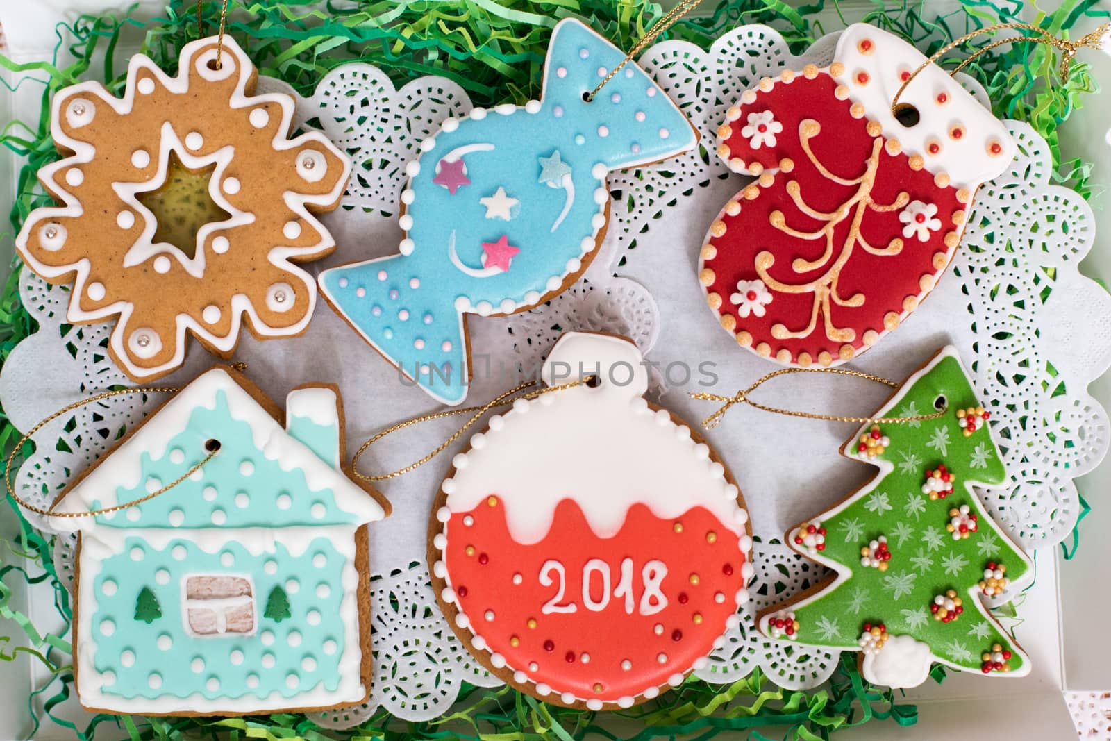 Close up of Christmas gingerbread set. Different colorful cookie figures seals, star, snowflake, candy, mitten, house, ball, christmas tree laying in box. Top view