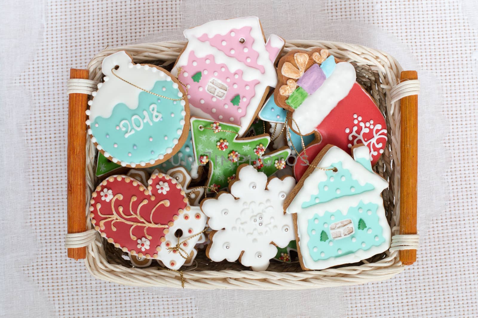 Close up of Christmas gingerbread set in the basket. Different colorful cookie figures, star, snowflake, sock, mitten, house, ball, christmas tree laying in box. Top view