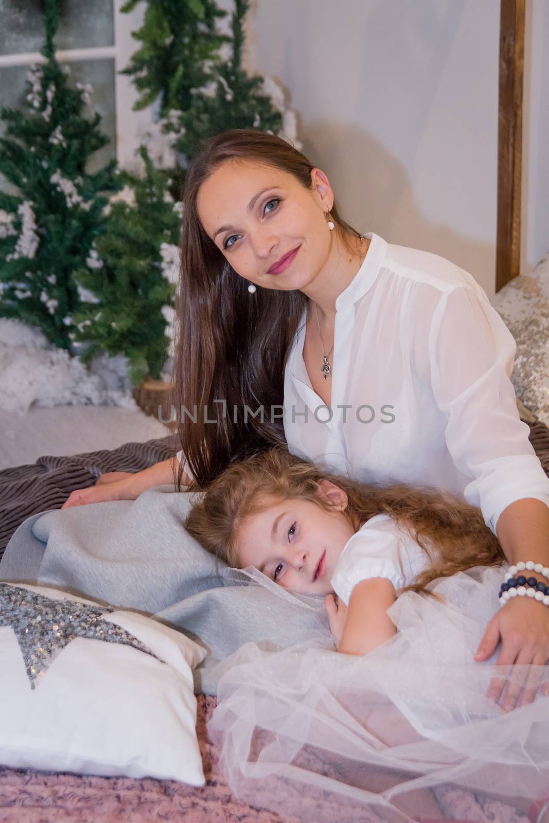 Mother and daughter in winter studio lying cosy