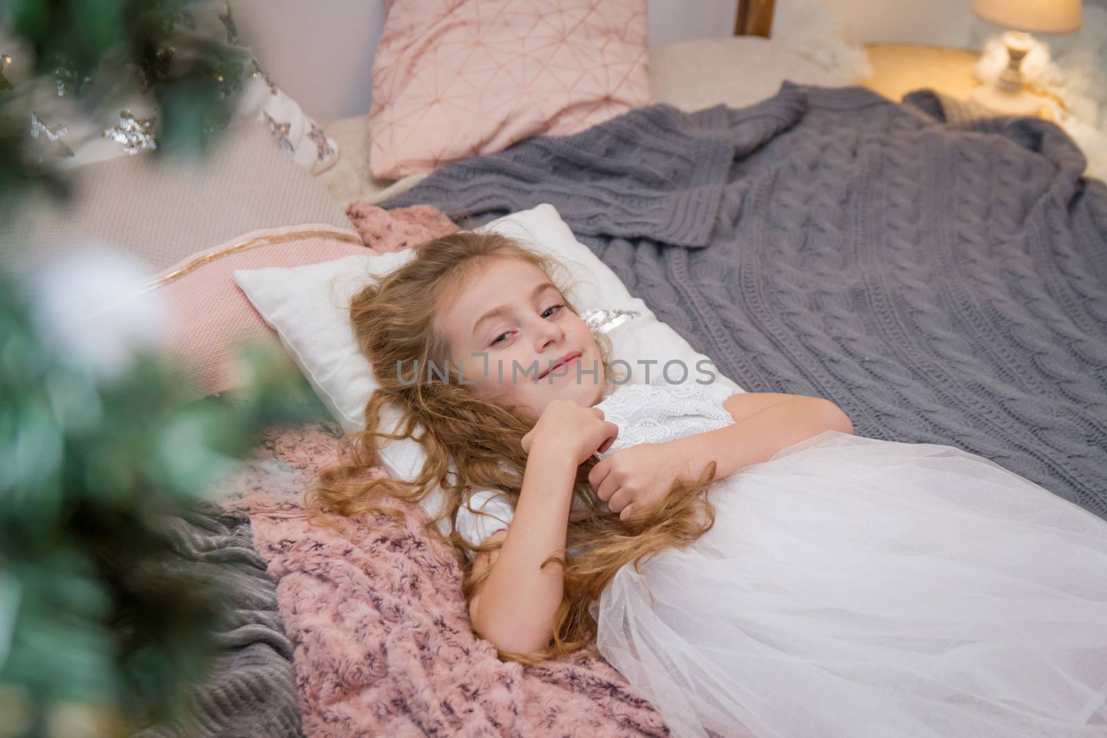 Smiling girl lying on pillow in winter studio