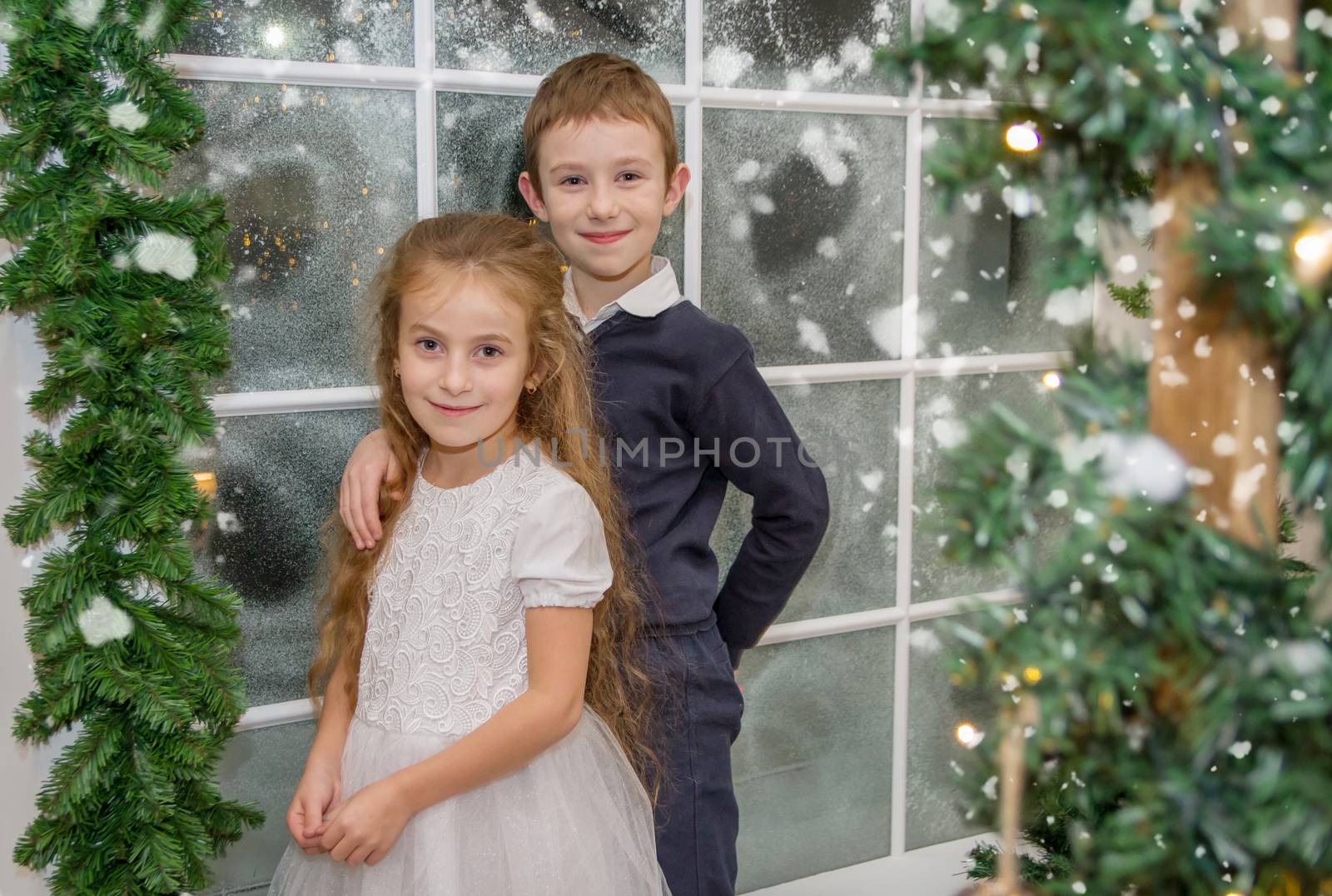 Smiling sister and brother in winter studio hugging