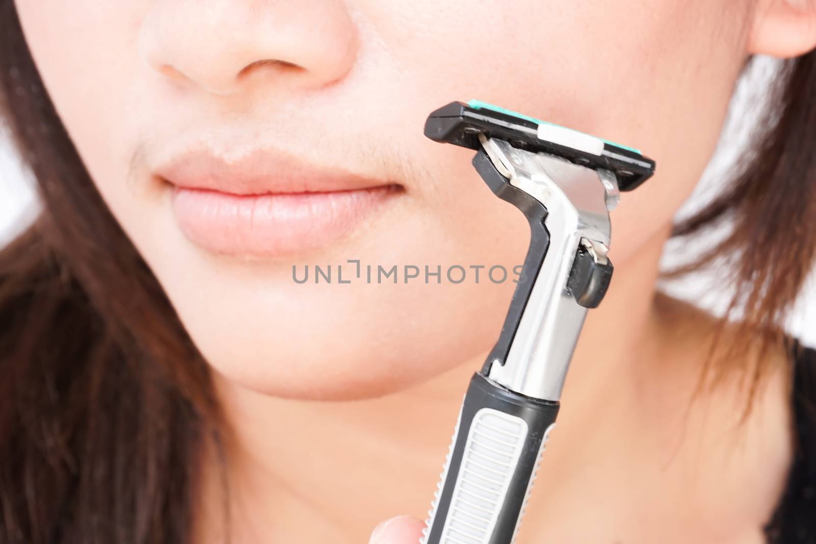 Closeup woman hand holding razor pre for shaving face, health care and beauty concept, selective focus