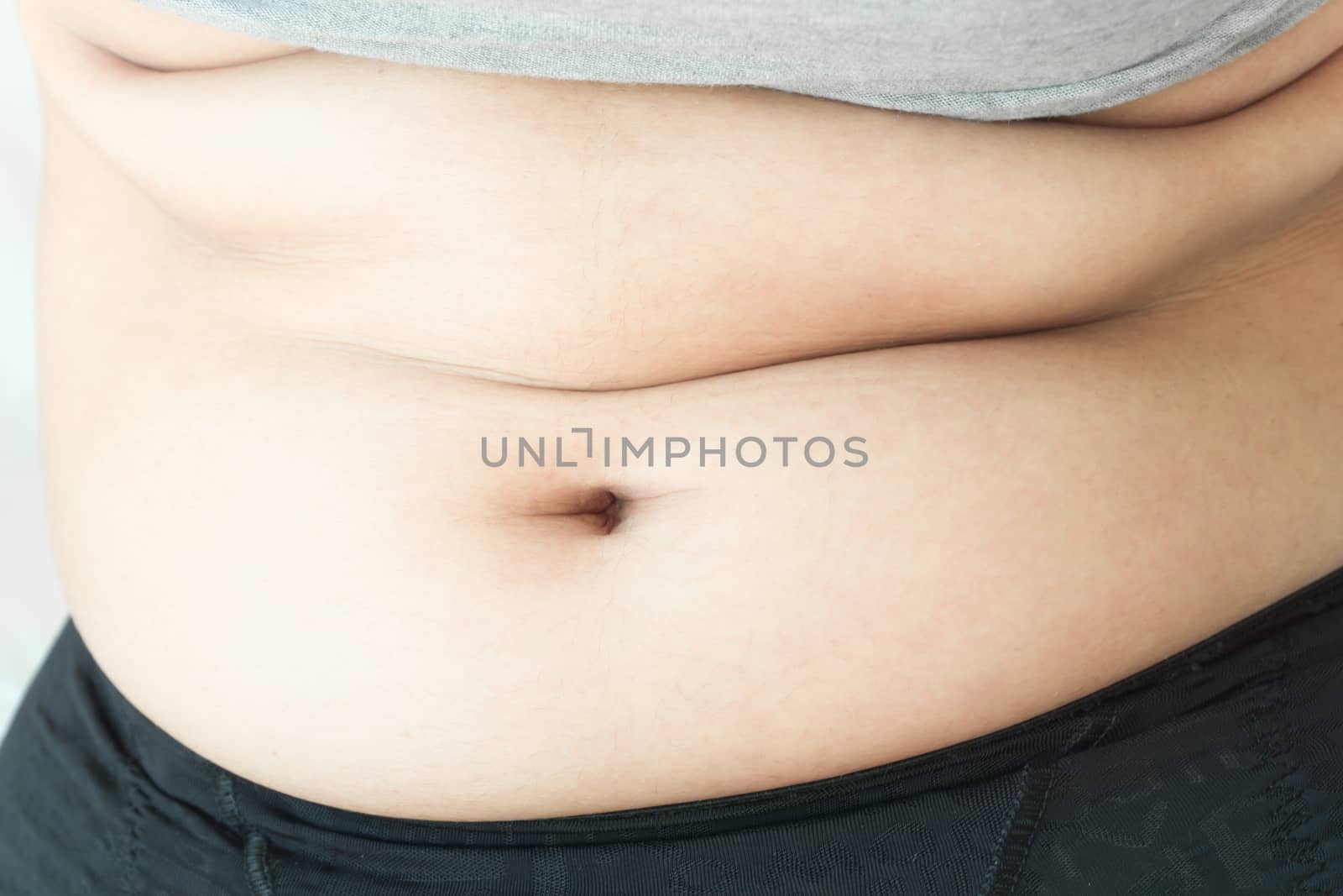 Closeup hand holding abdominal surface woman fat, healthy care and beauty concept