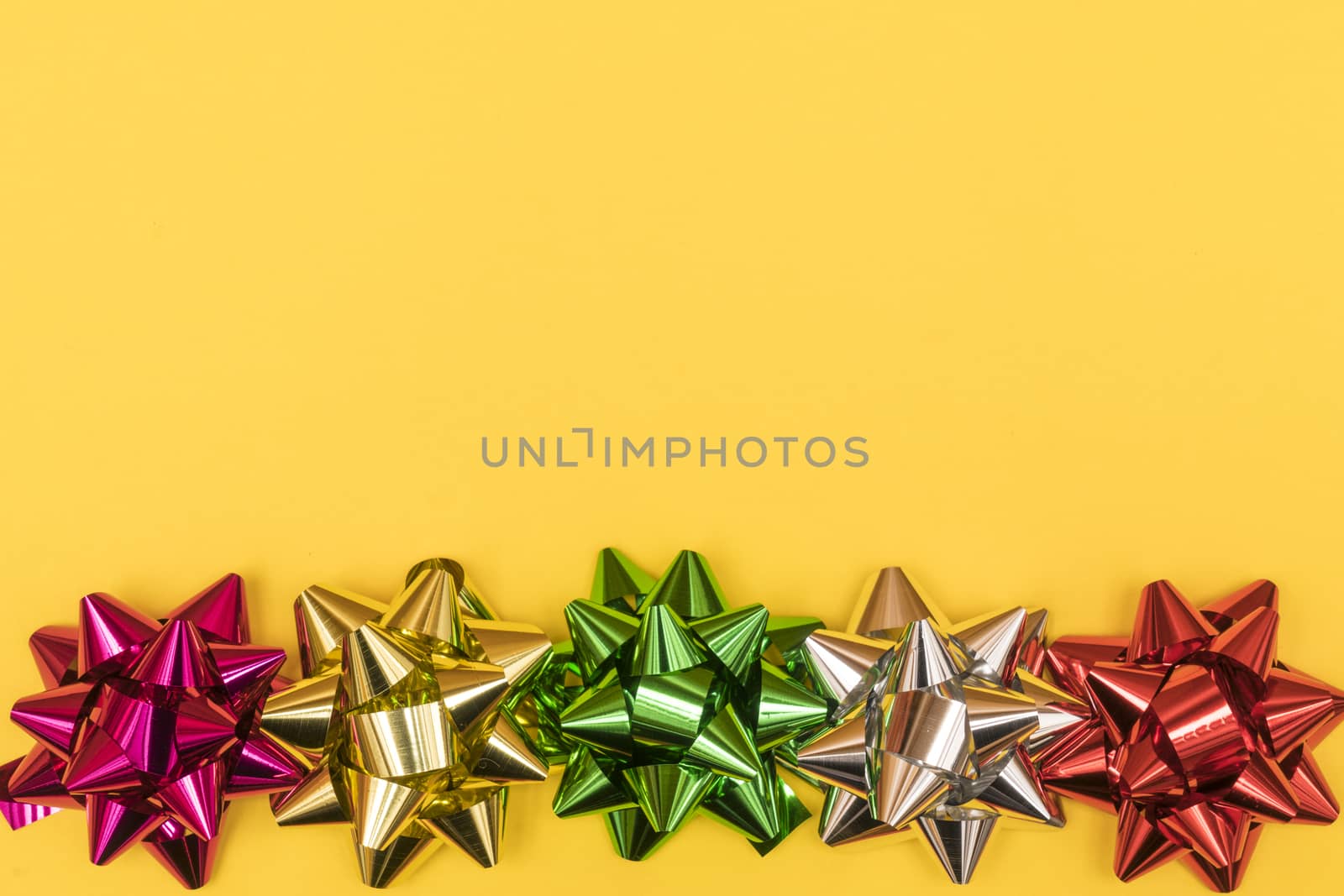 Christmas decorative colored bows  on a yellow background