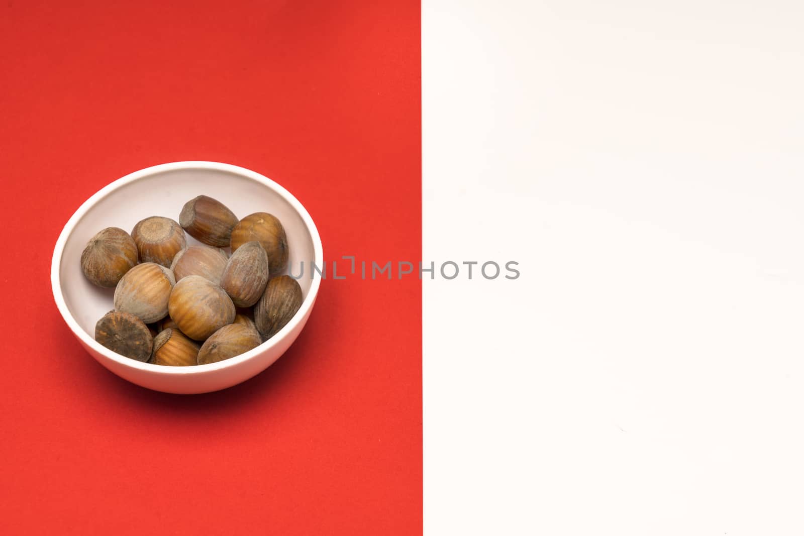 hazelnuts in a bowl on a colored background