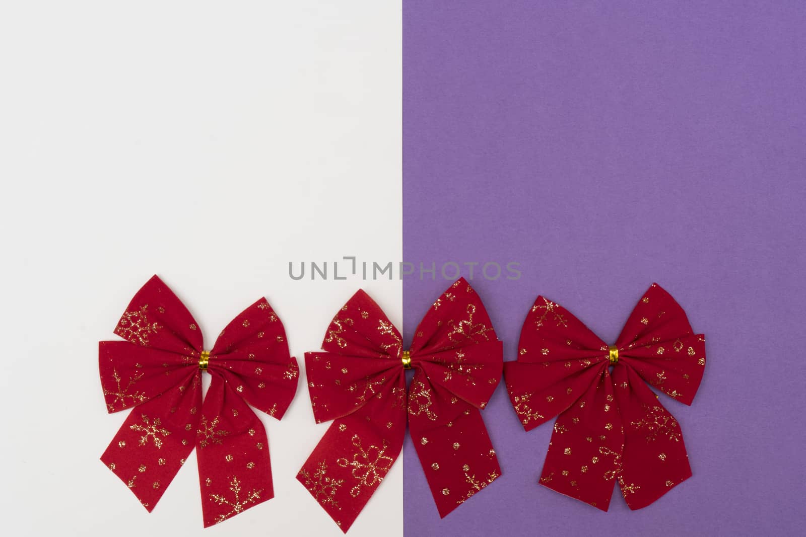 red Christmas bows on a colored background