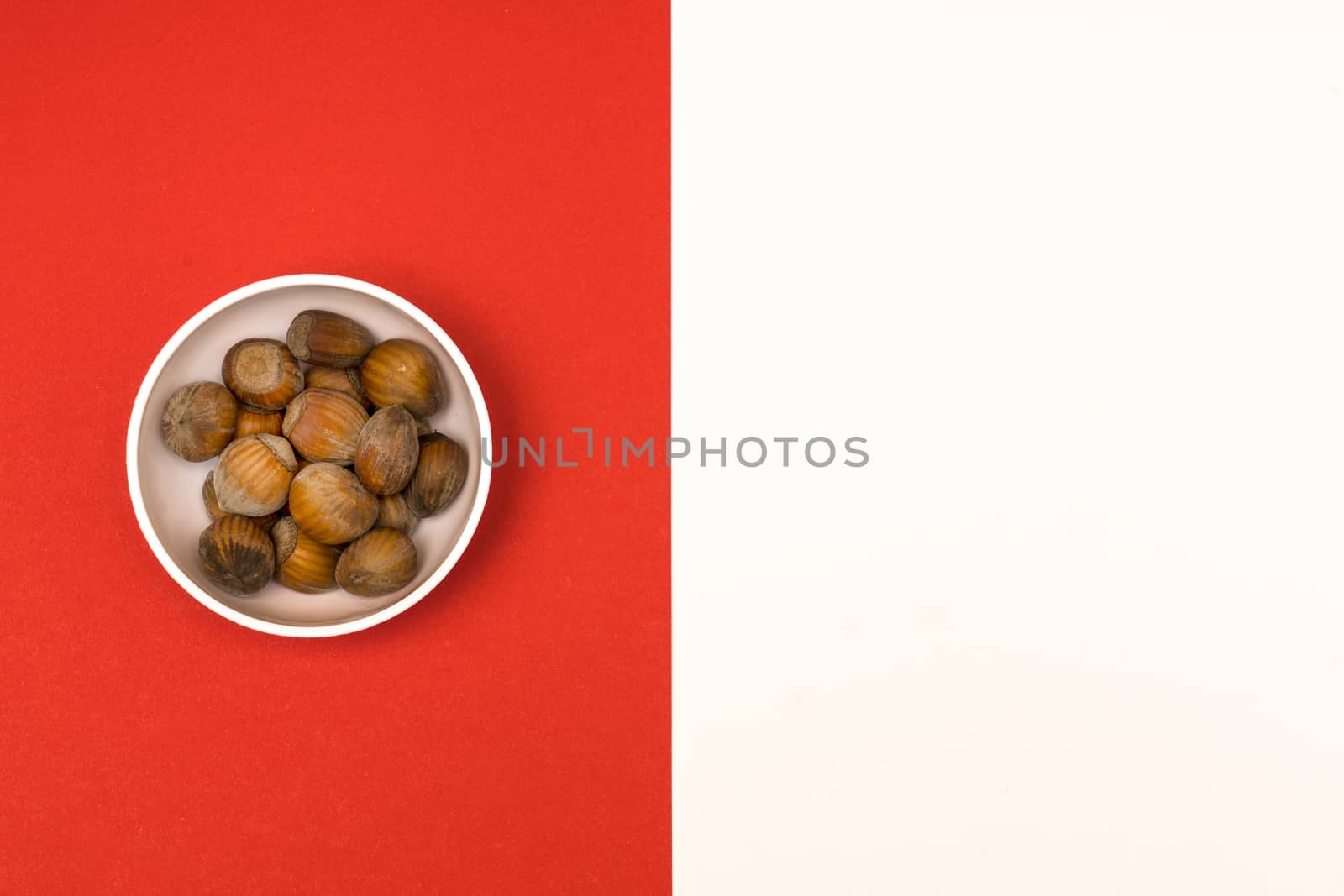 hazelnuts in a bowl on a colored background