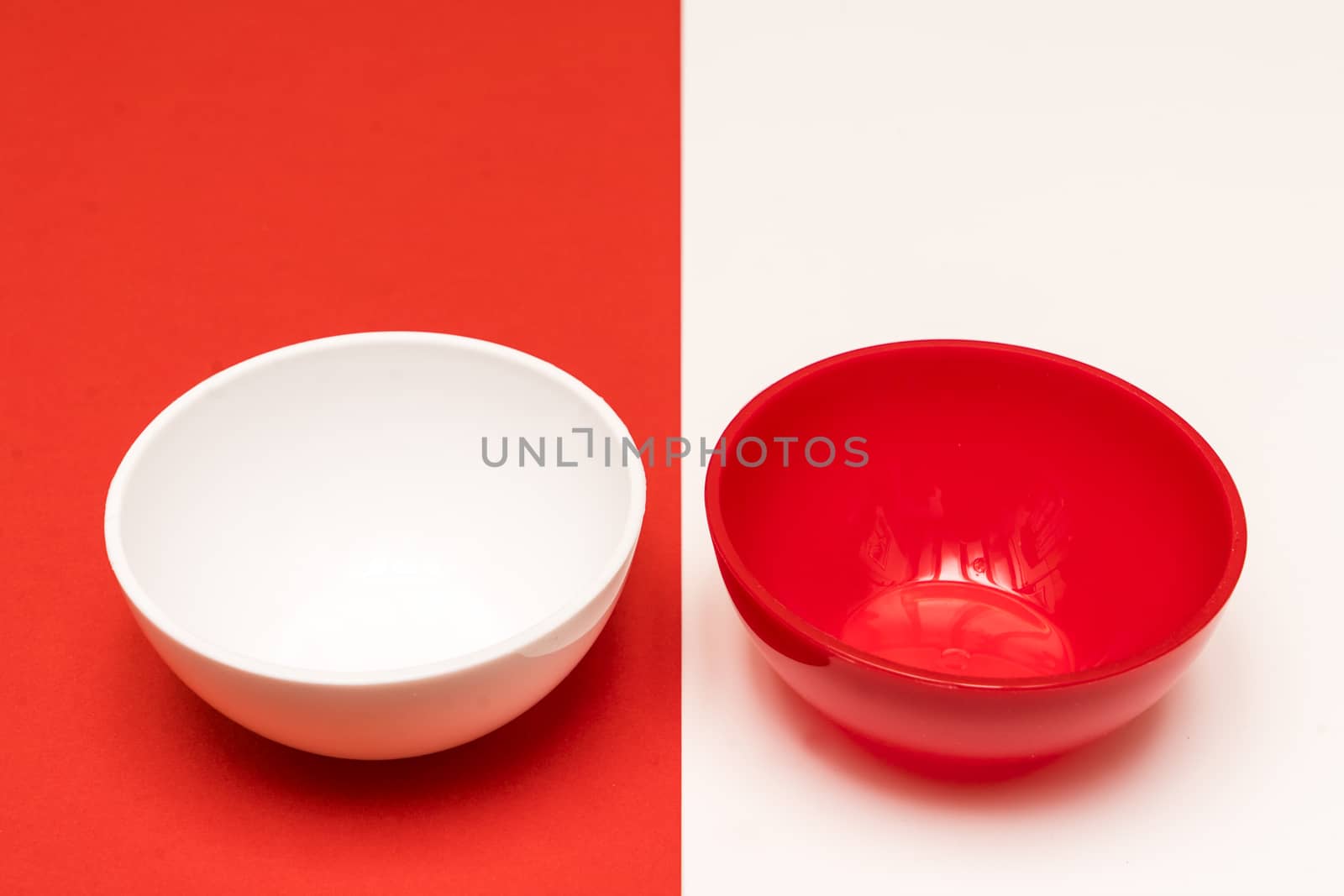 red and white bowls arranged opposite each other on a colored background