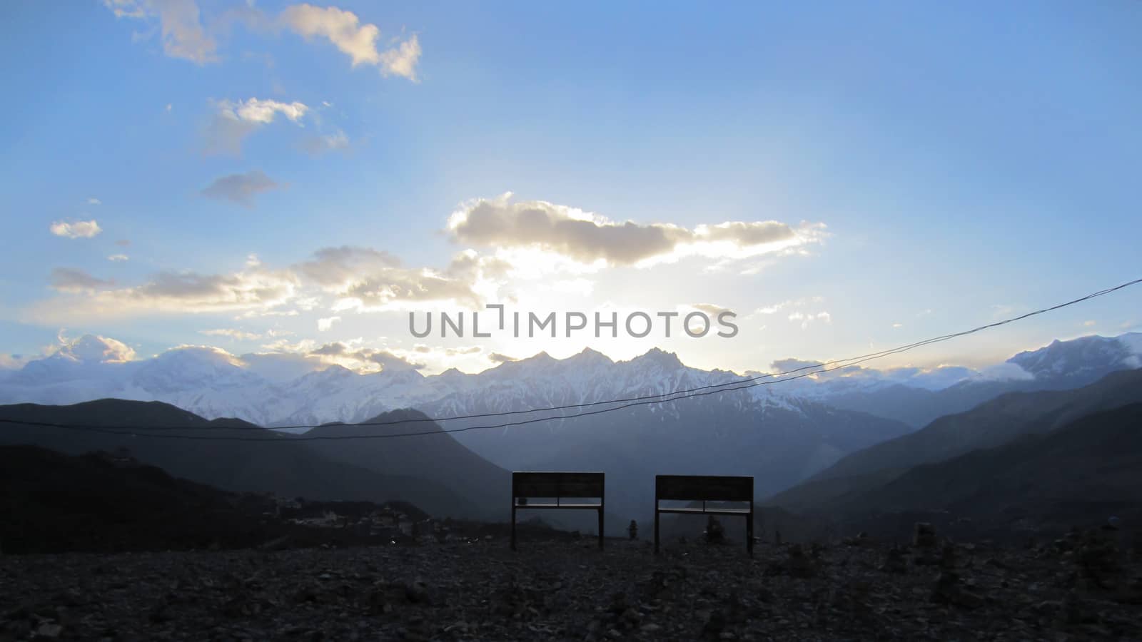 Two empty benches watching the Sunset in the Annapurna region on a cloudy day.