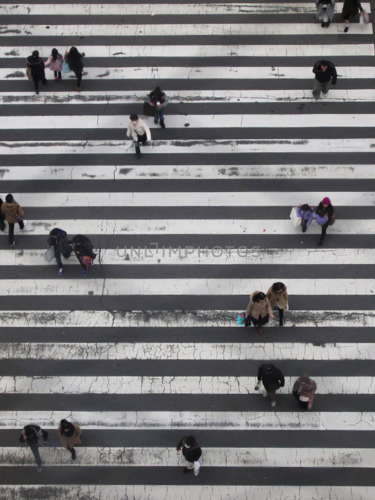 KYOTO, JAPAN - JANUARY 19, 2015: Bird view close up on a big black white crossing in Tokyo while Japanese people are walking over on January 19, 2015 in Kyoto, Japan.
