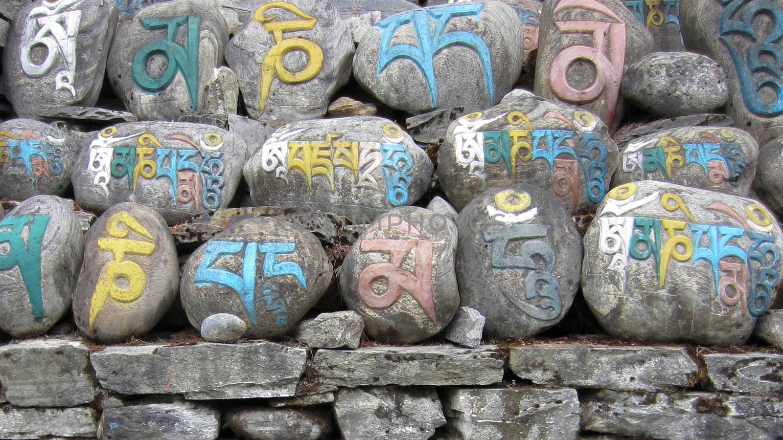 ANNAPURNA, NEPAL - APRIL 12, 2015: Buddhist mani wall made out of stones with colorful signs on April 12, 2015 in Annapurna, Nepal.