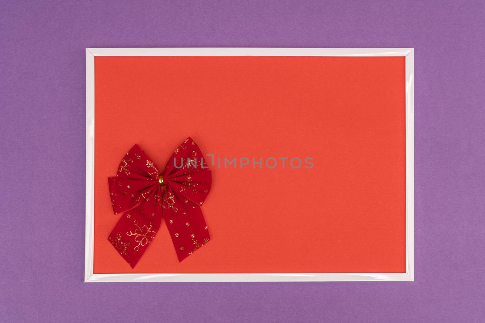 Christmas decorative bow in a white frame on a colored background