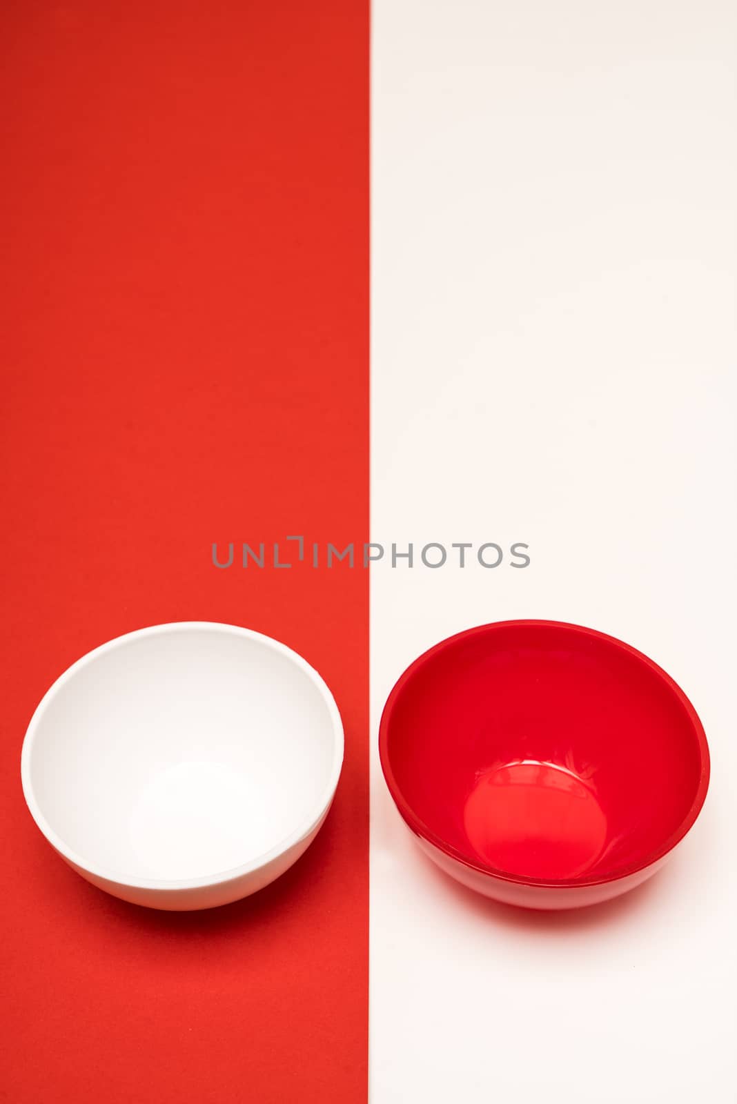 red and white bowls arranged opposite each other on a colored background