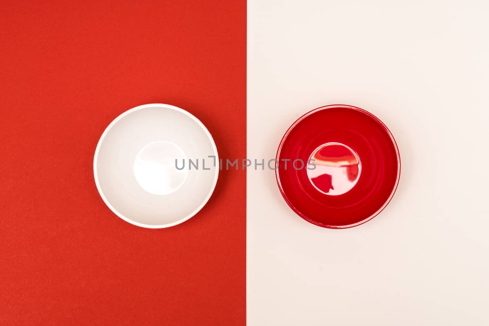 red and white bowls arranged opposite each other on a colored background