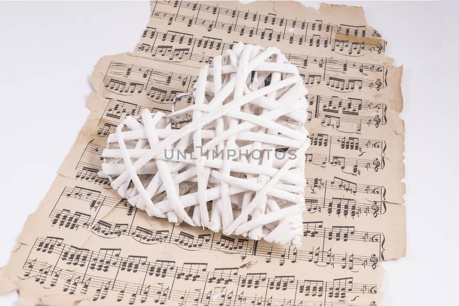 heart made with white wooden slats over a musical score