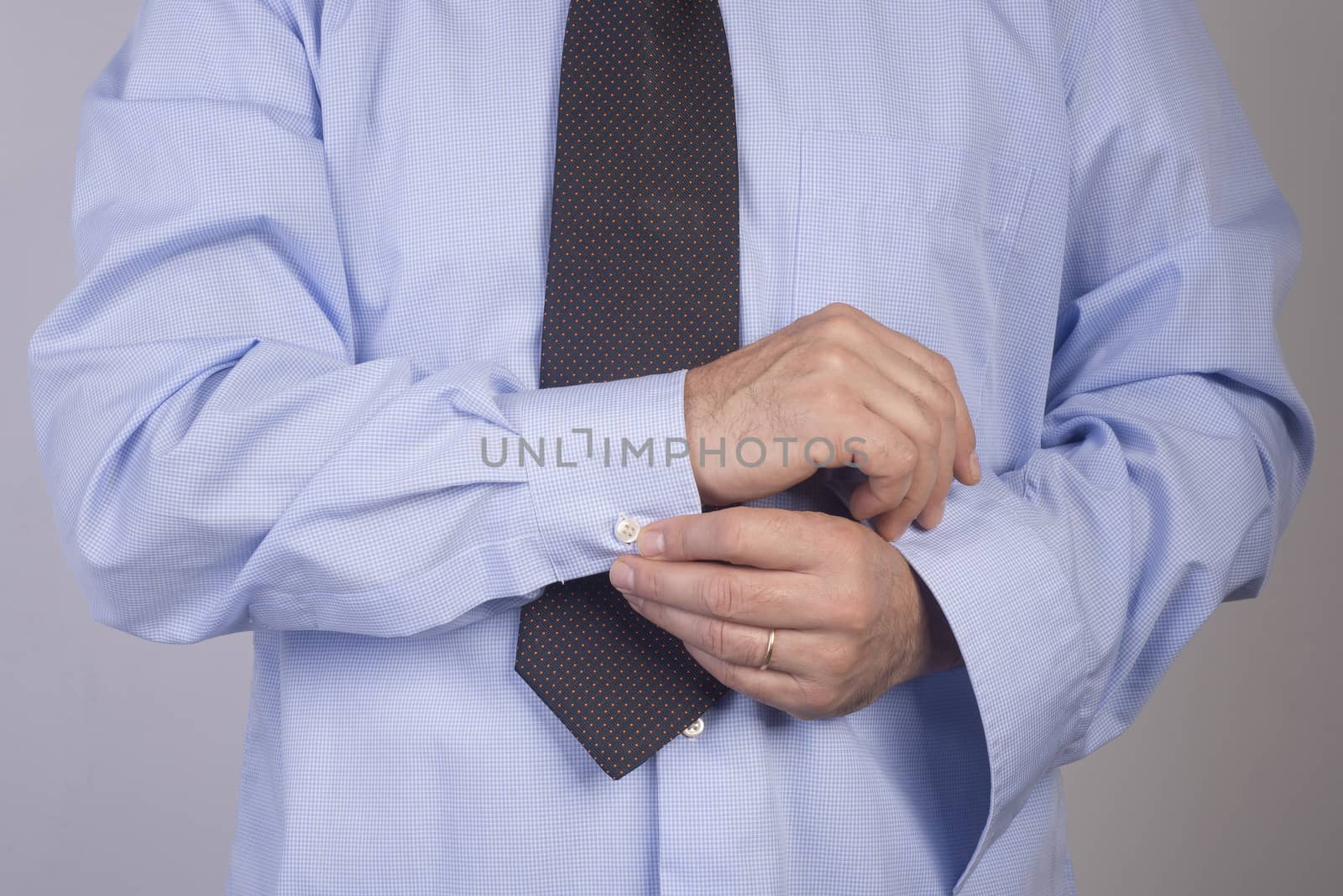 man buttoning his shirt