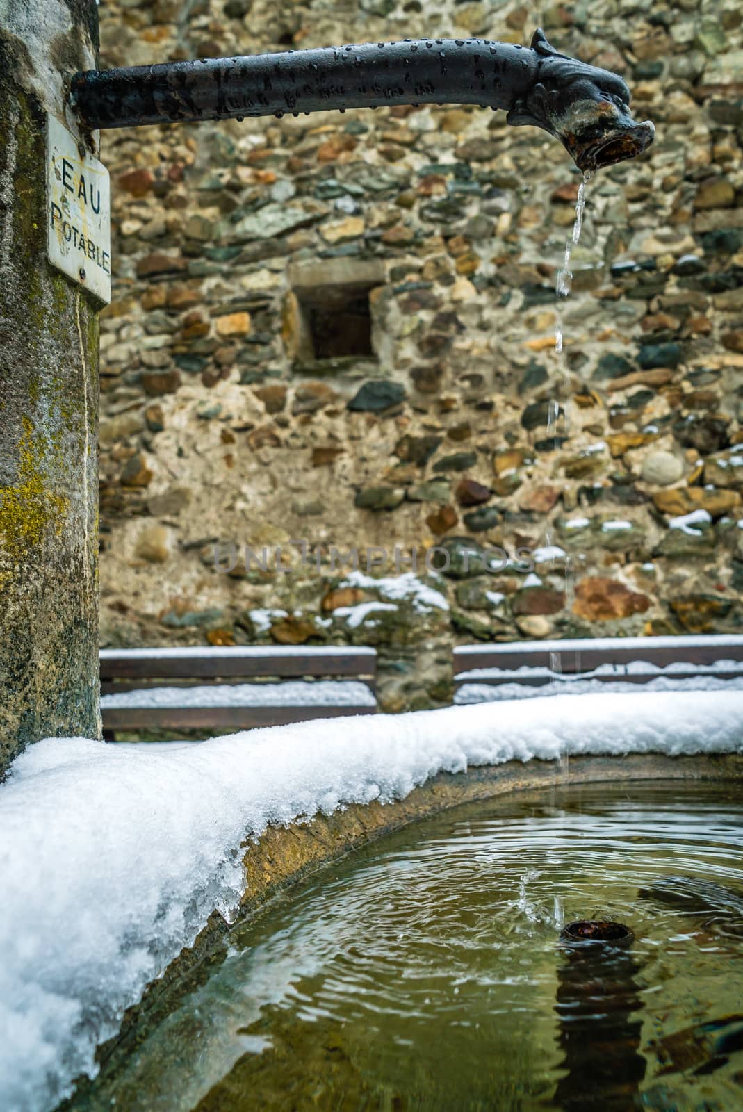 Fountain with snow in the mountains in the winter