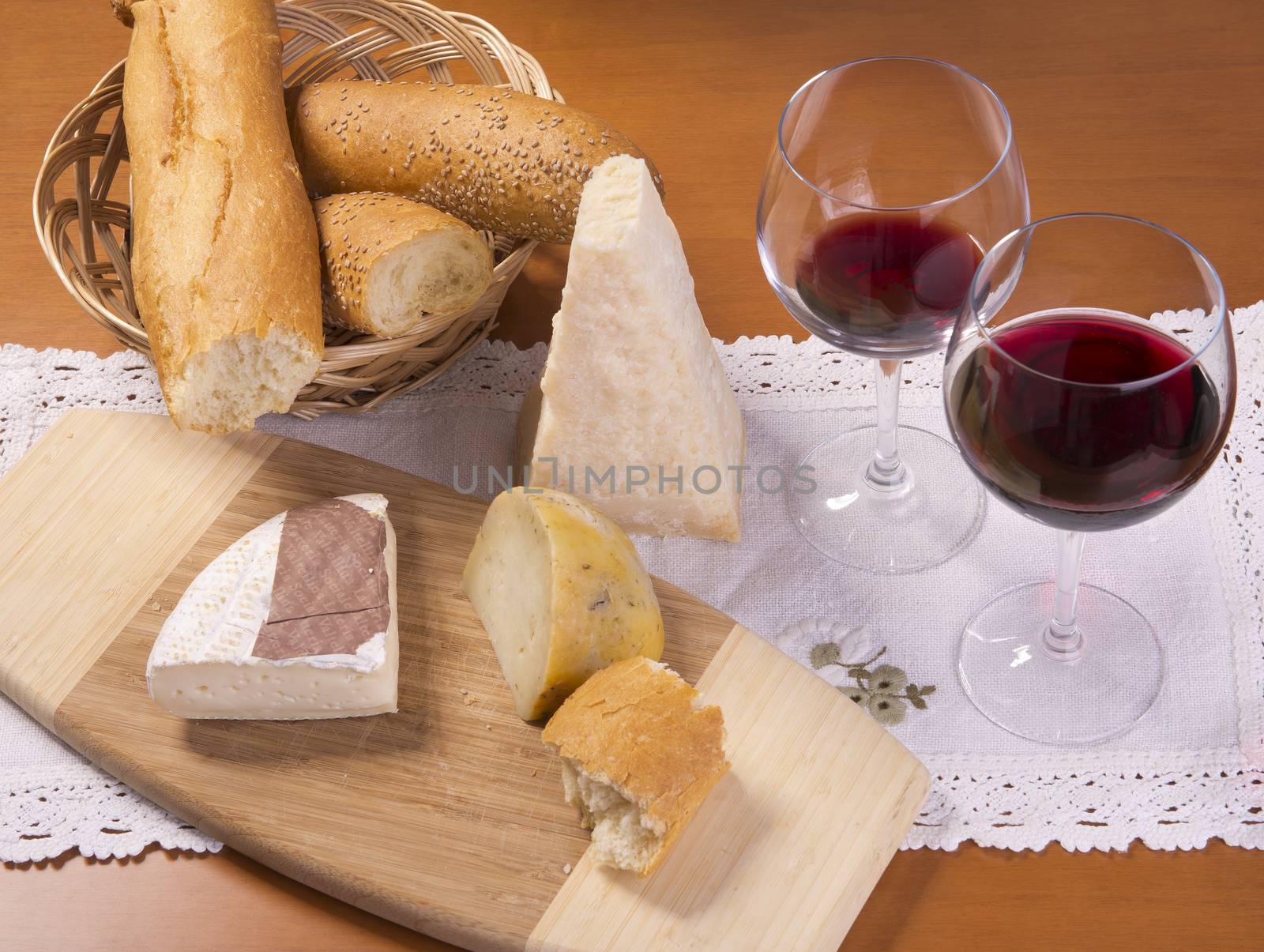 cheeses bread and red wine on the table