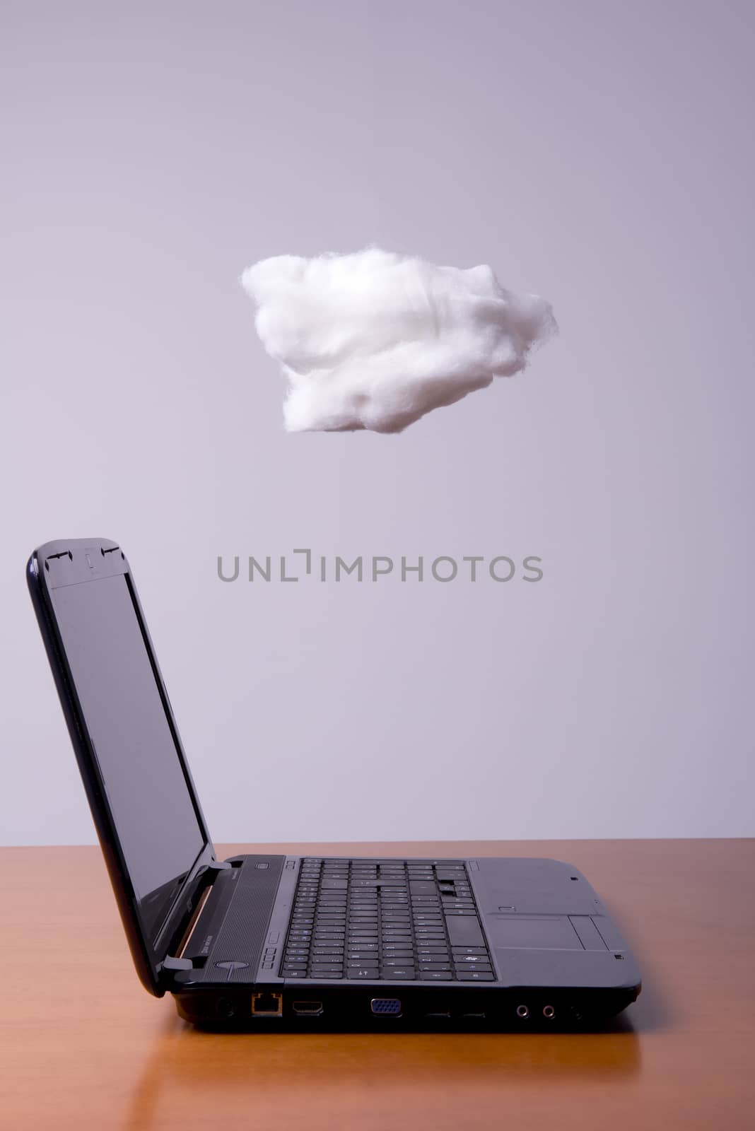 a laptop on the table with the cloud above