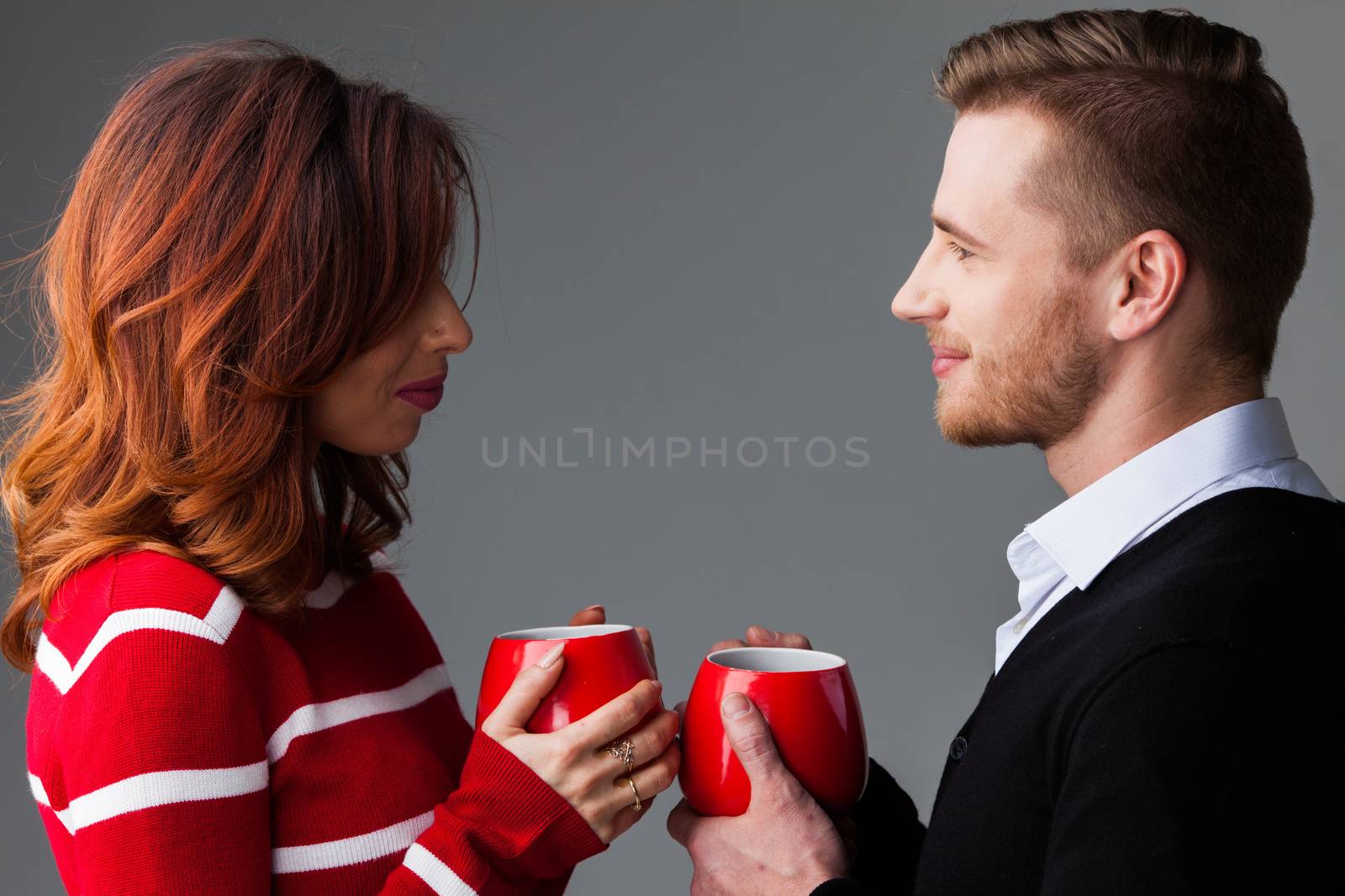 Young couple holding red coffee mags, Valentine's day concept