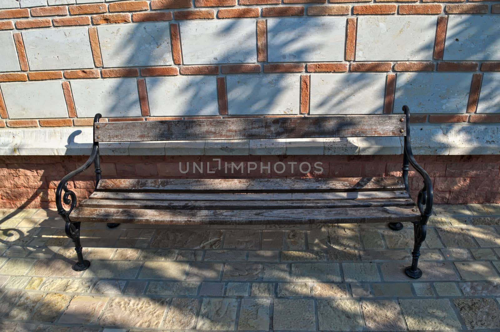 Wooden bench in front of bricks wall by sheriffkule